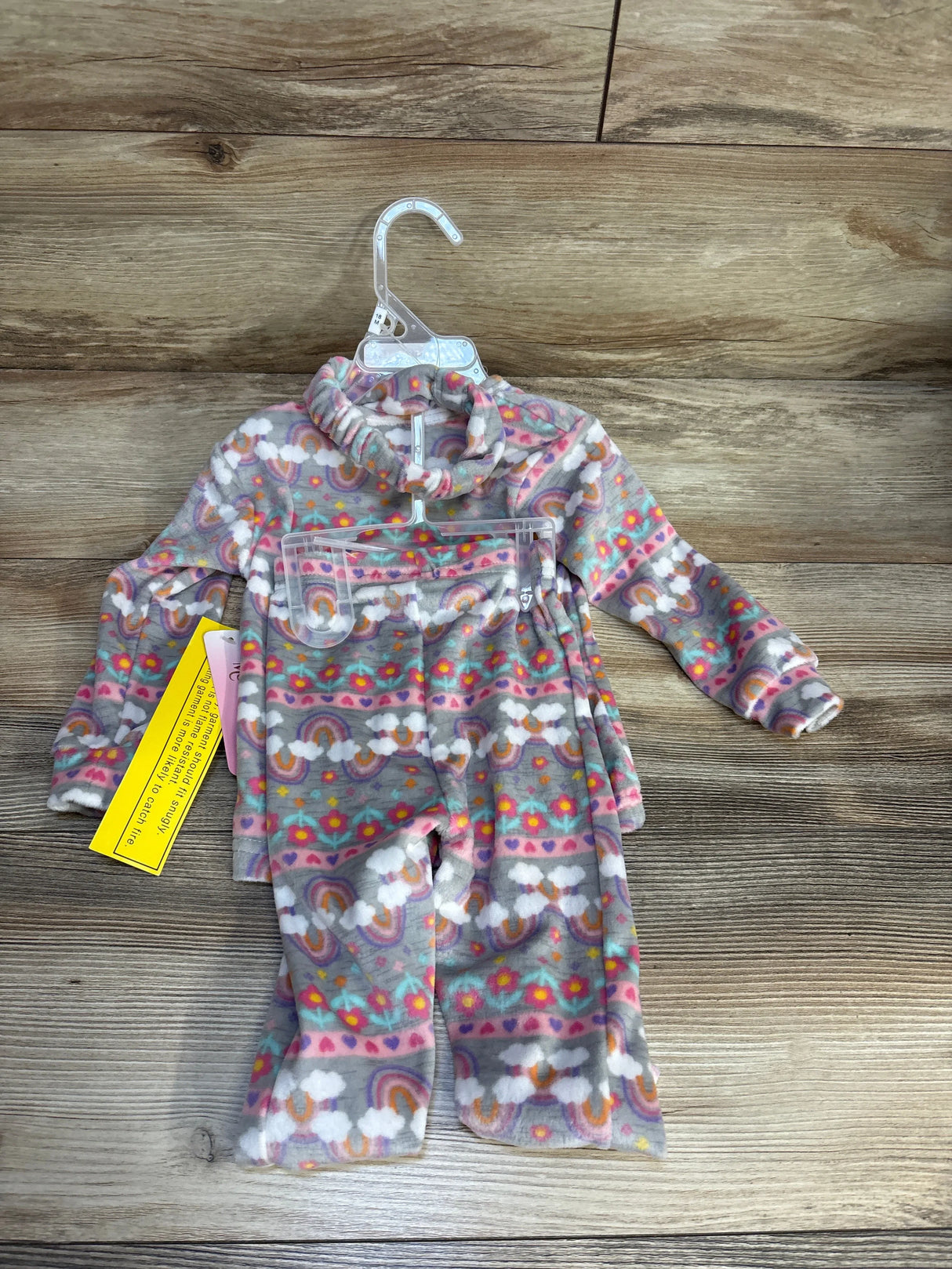 Fleece toddler pajama set with rainbow and floral print on wooden background