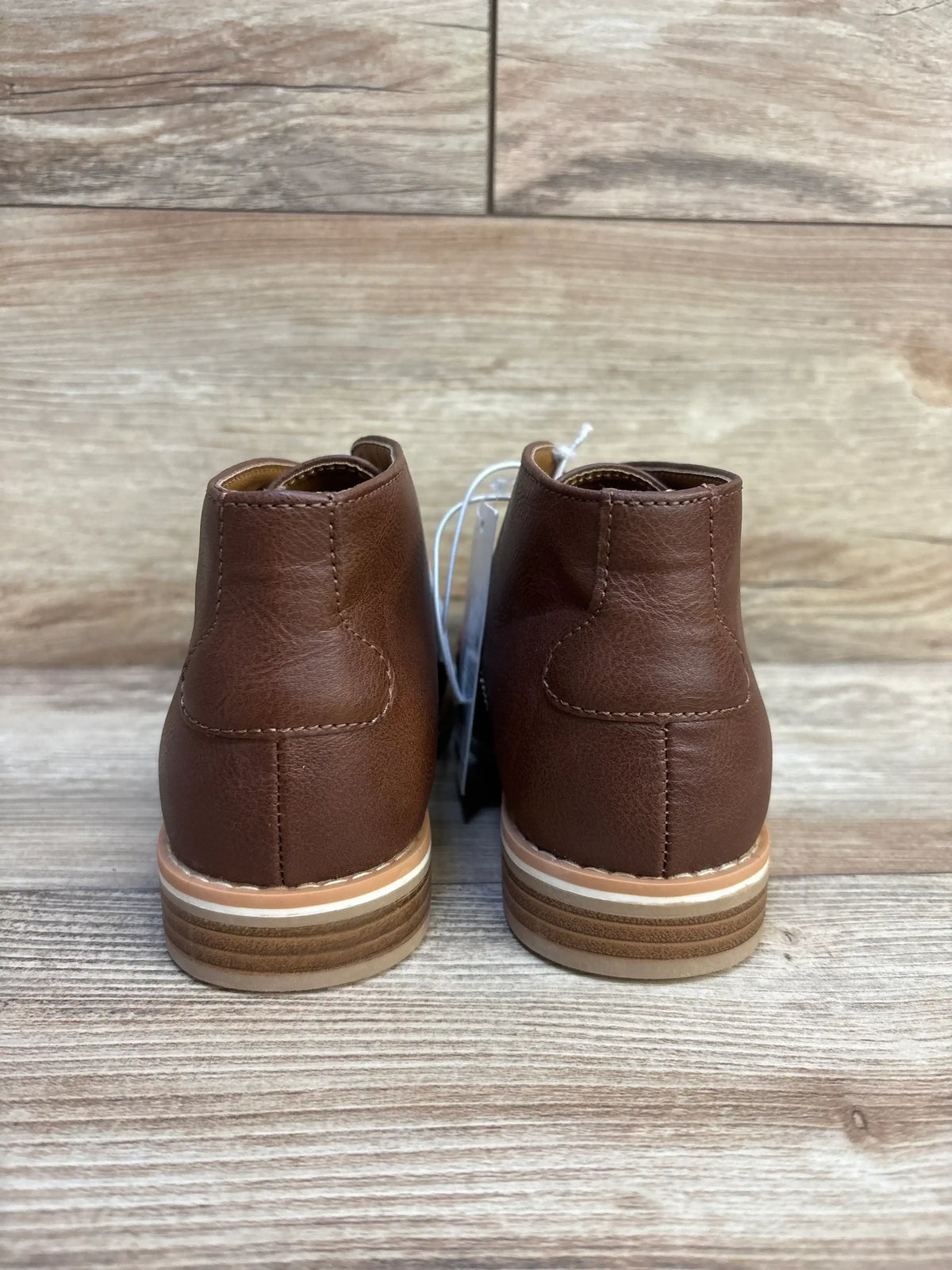 Back view of Cat and Jack Filip boots in brown, size 2Y showcasing stitched panels and layered soles on a wood floor