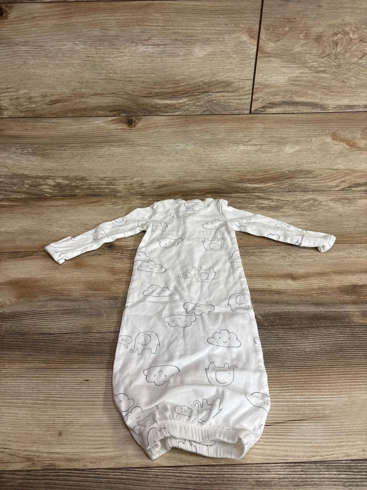 Front view of Carter’s Cloud Henley Sleeper Gown in white showcasing long sleeves and cloud print on a wood floor