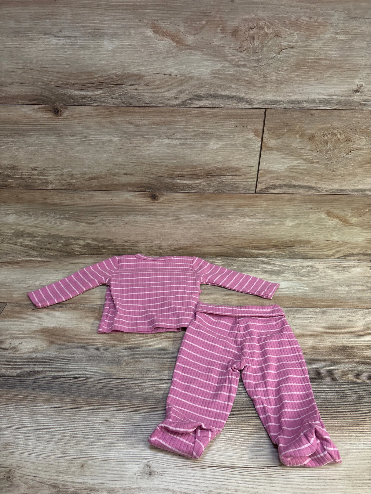 Flat lay of pink and white striped baby kimono top and matching pants with elastic waist on wood background