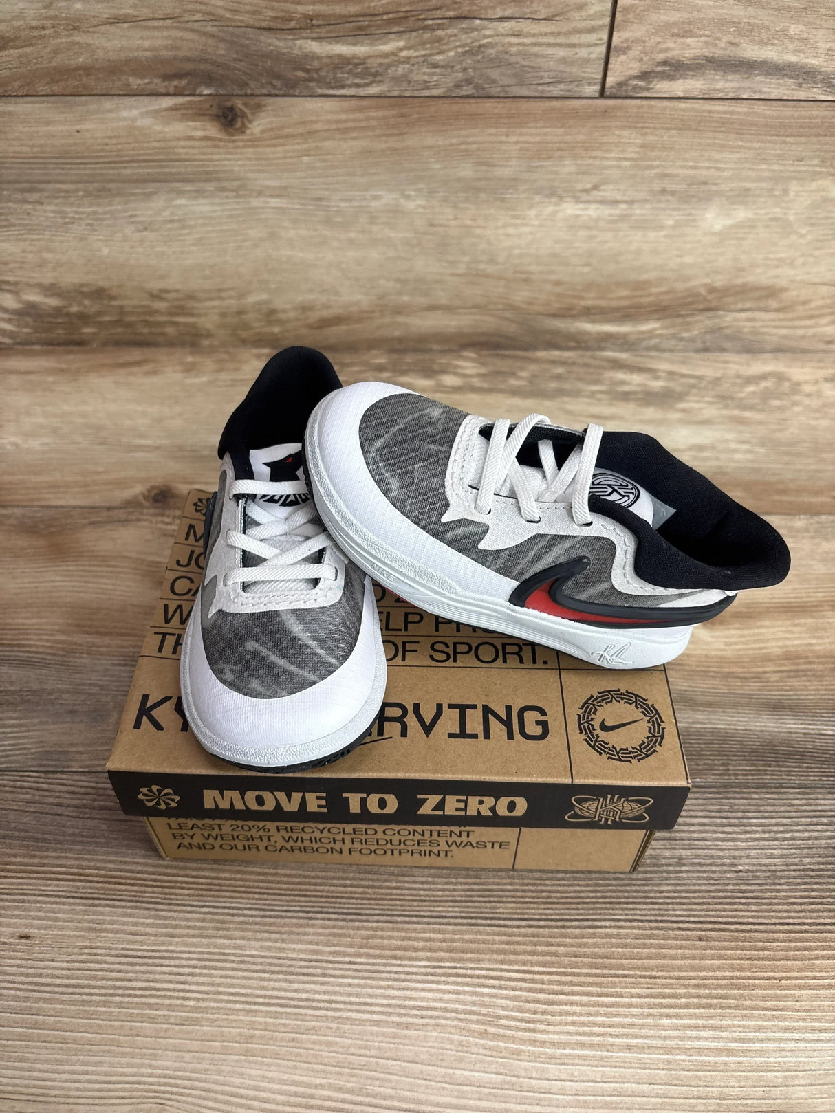 Top-front view of Nike Kyrie 8 TD toddler sneakers, white and university red, showing red Swoosh on a Move to Zero shoebox