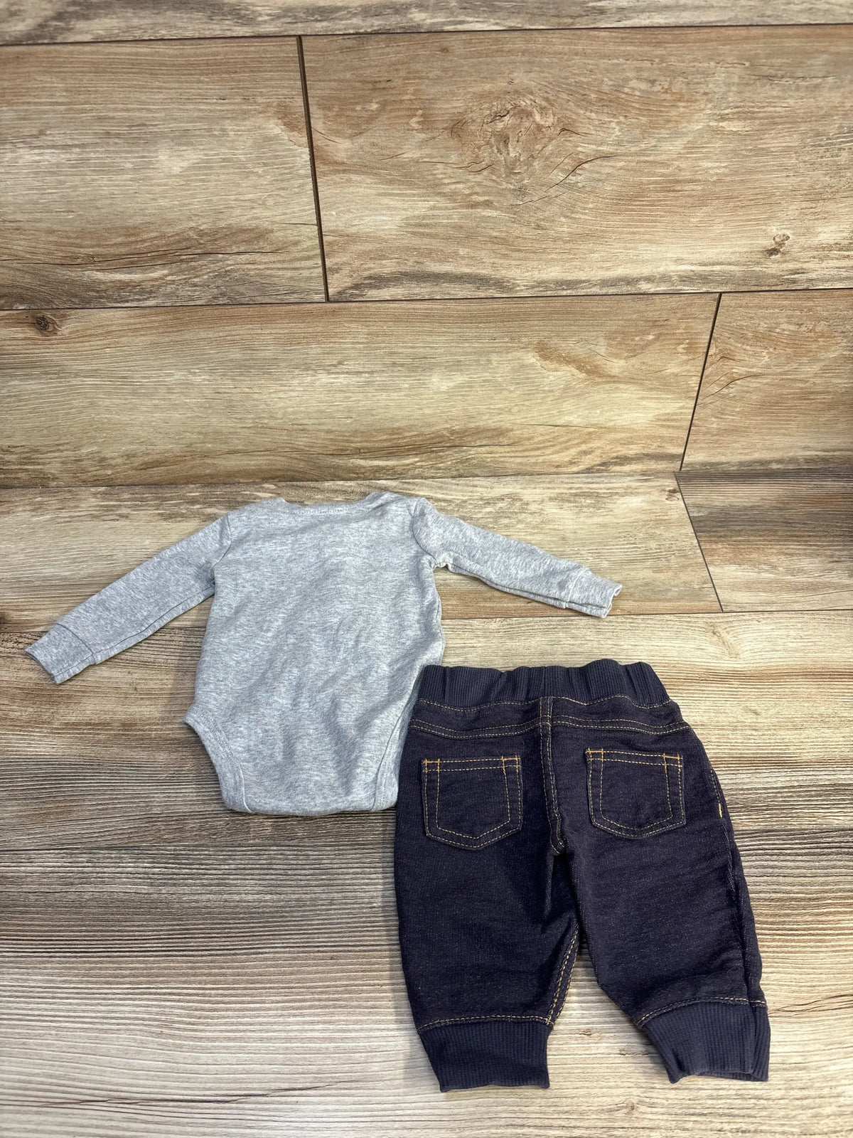 Top-down view of Carter’s 2pc henley bodysuit and jeggings set showcasing a grey long-sleeve bodysuit and dark jeggings