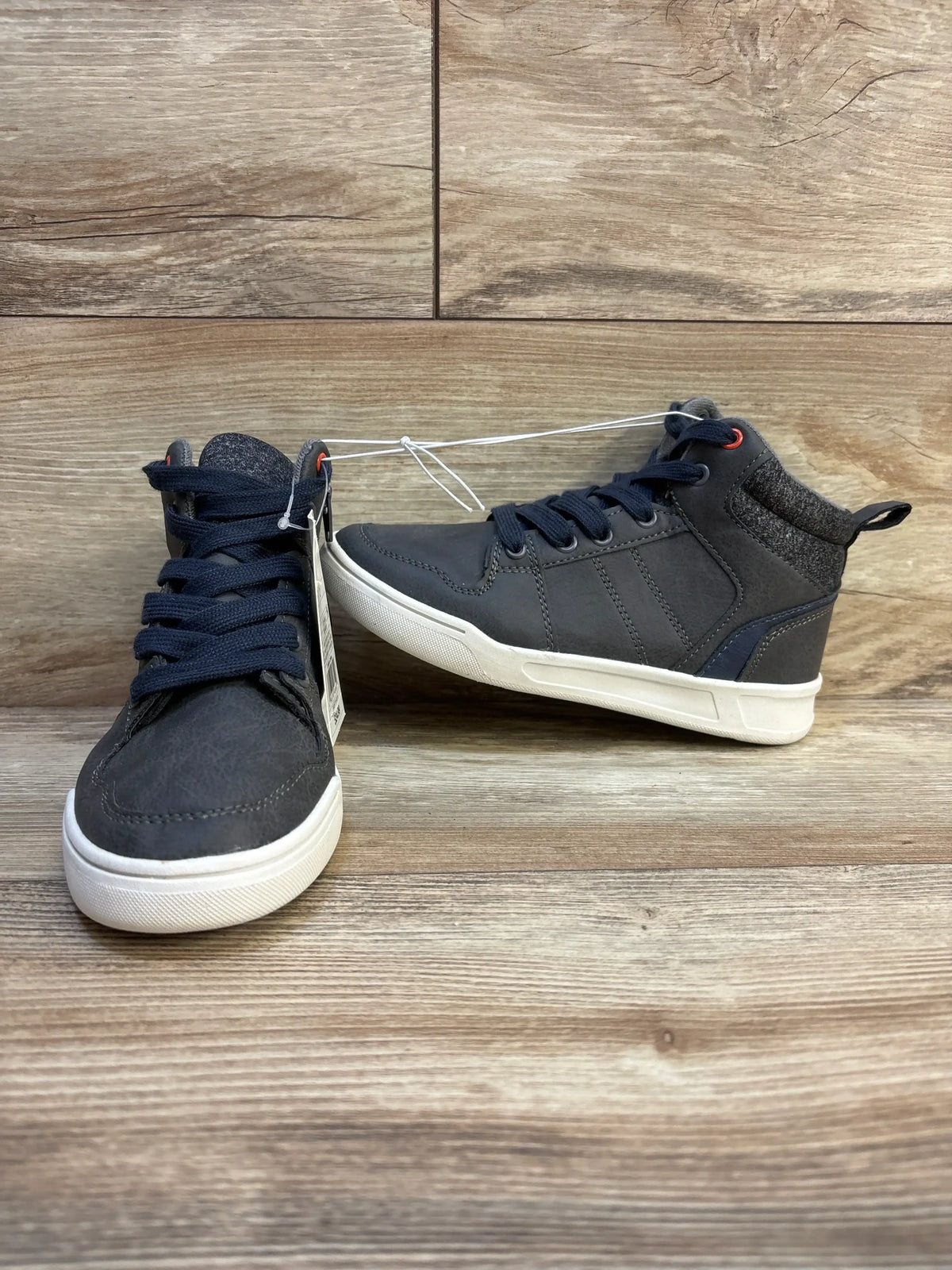 Front and side view of Art Class Geoff high-top sneakers showing navy laces, knit cuff and white soles on wood background