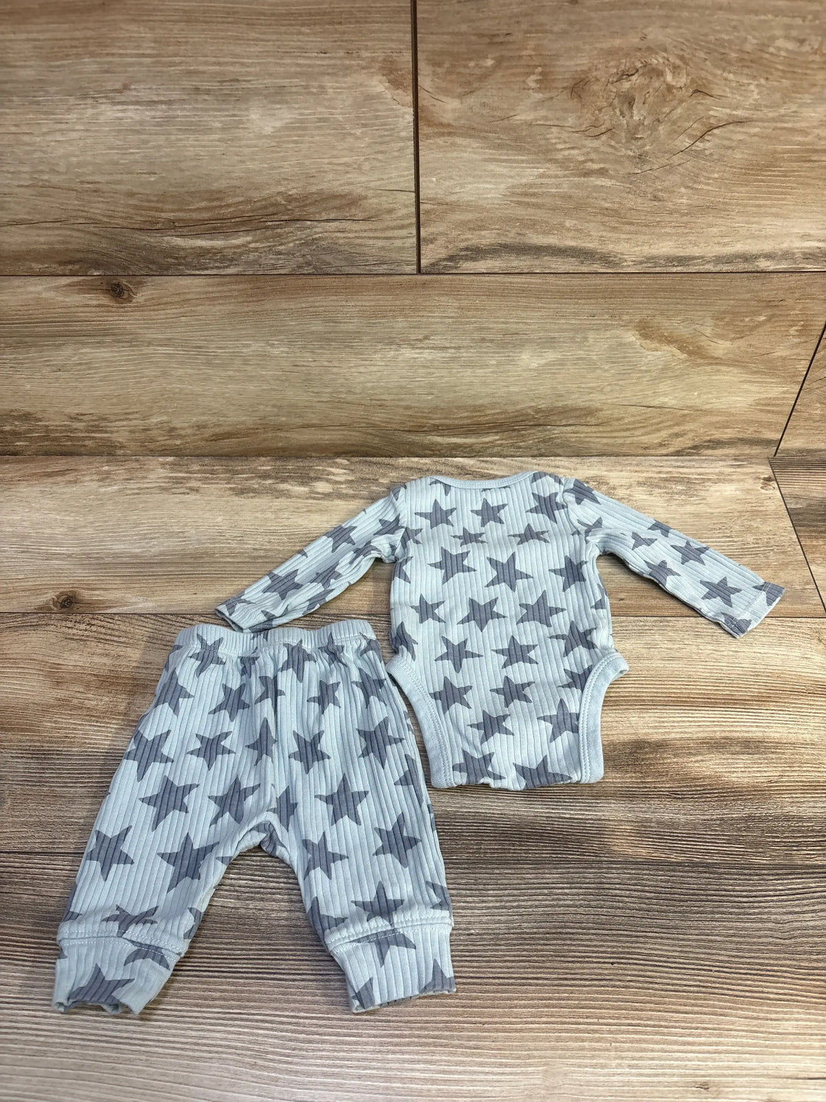 Cloud Island ribbed blue baby bodysuit and pants set with grey star print on wooden background