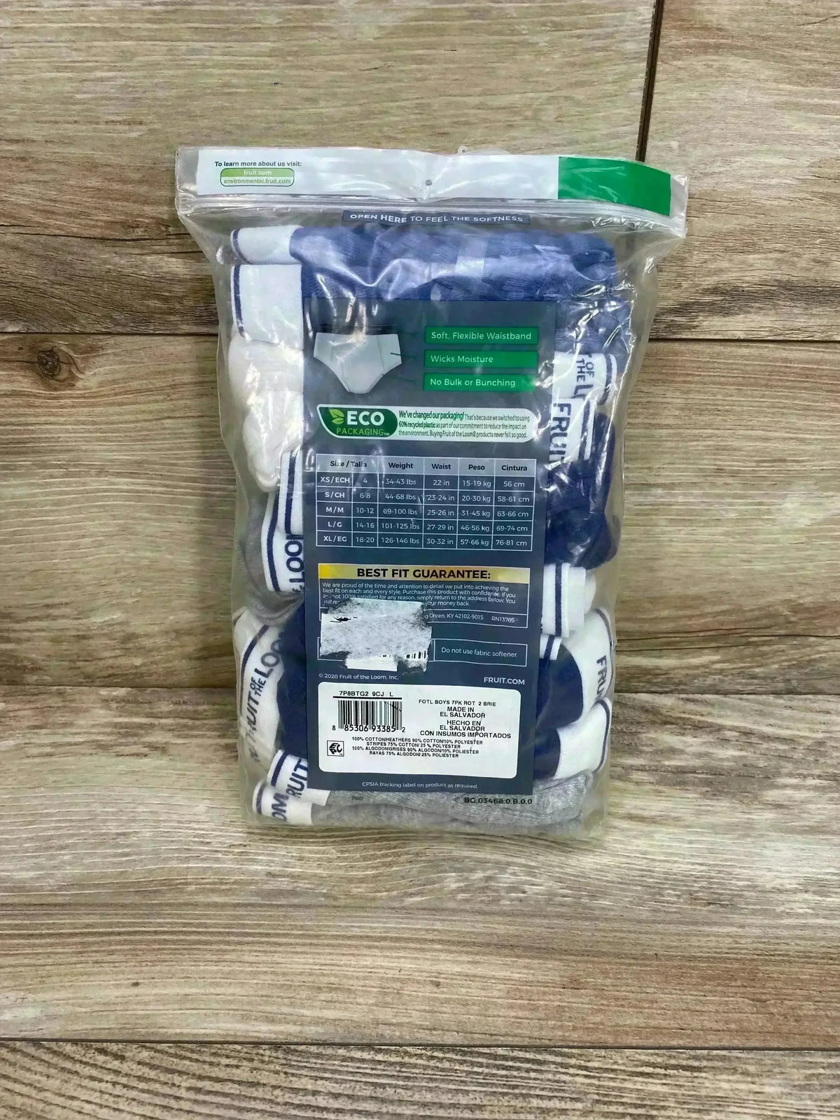 Front view of Fruit of the Loom 7-pack classic briefs in clear bag showing white and blue waistbands and size L/14-16 on wood