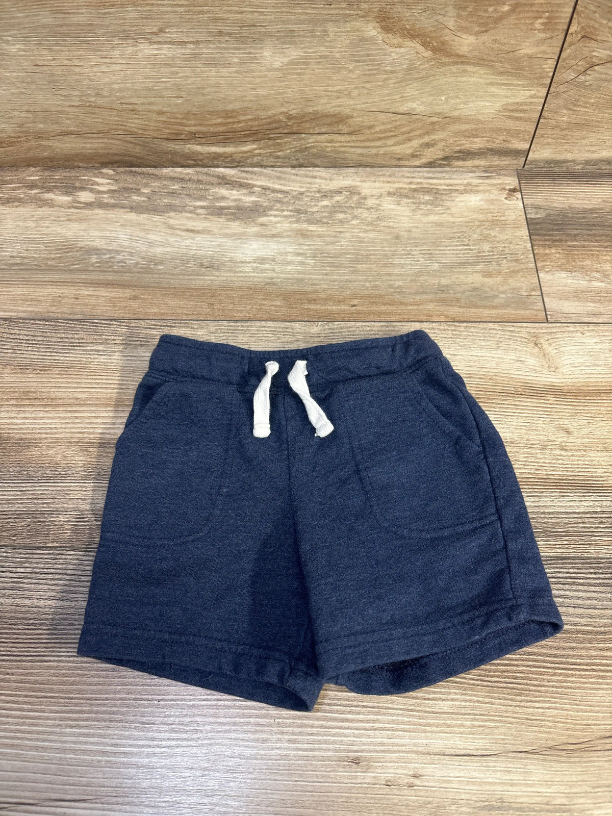Cat & Jack blue drawstring shorts for toddlers size 2T on a wooden surface