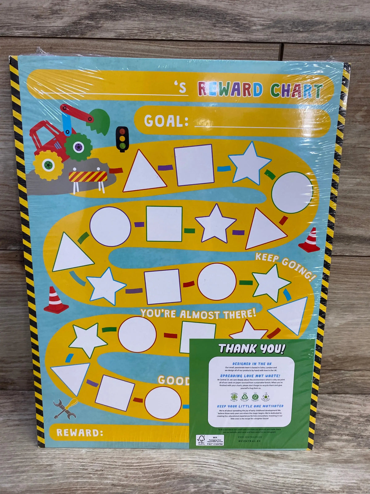 Front of kids’ reward chart showing yellow path, blank shape stickers, ‘Goal’ and ‘Reward’ fields, construction icons on wood
