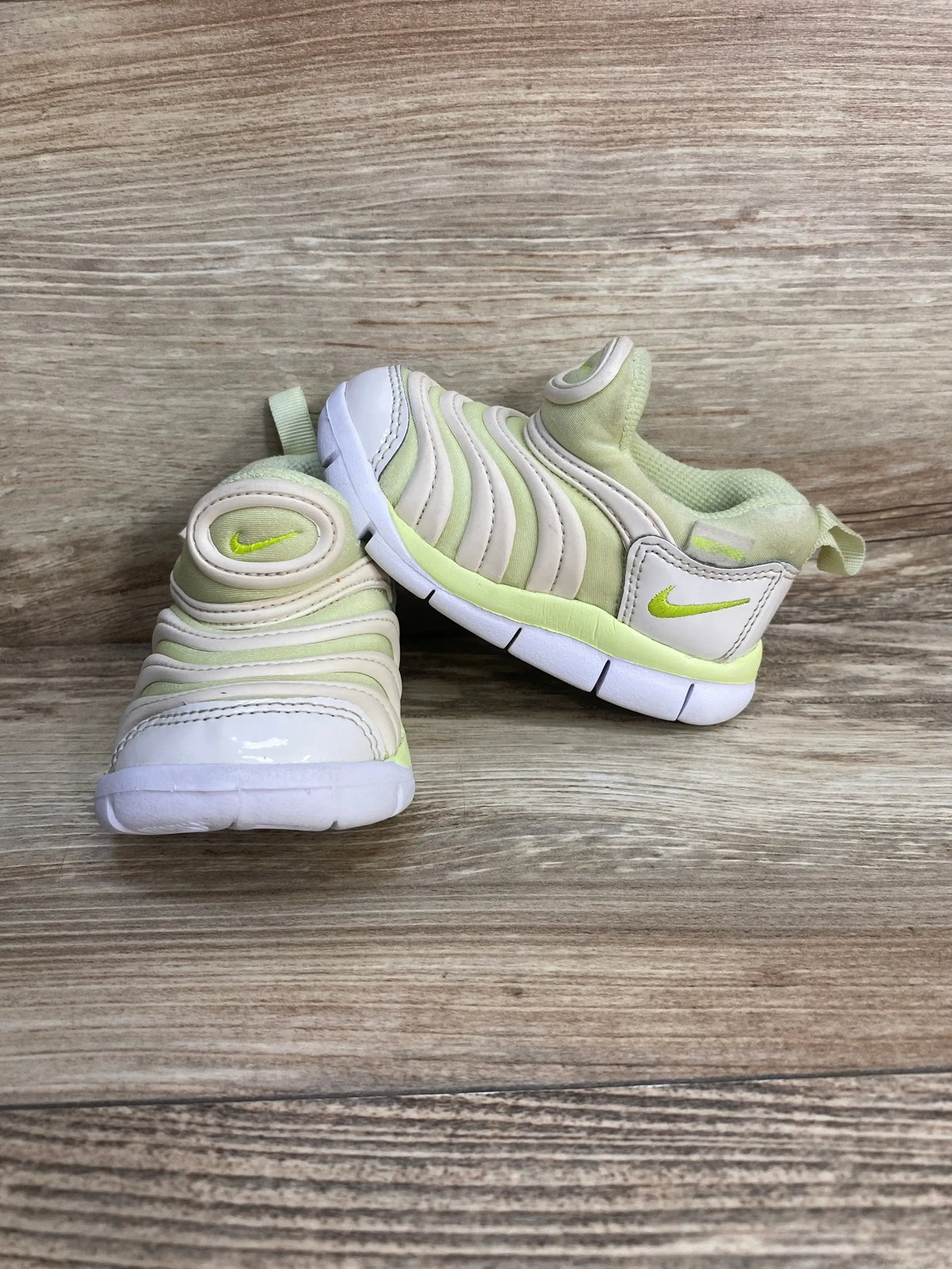 Front and side view of Nike Dynamo Free toddler sneakers in white and lime green with slip-on upper and flexible white sole