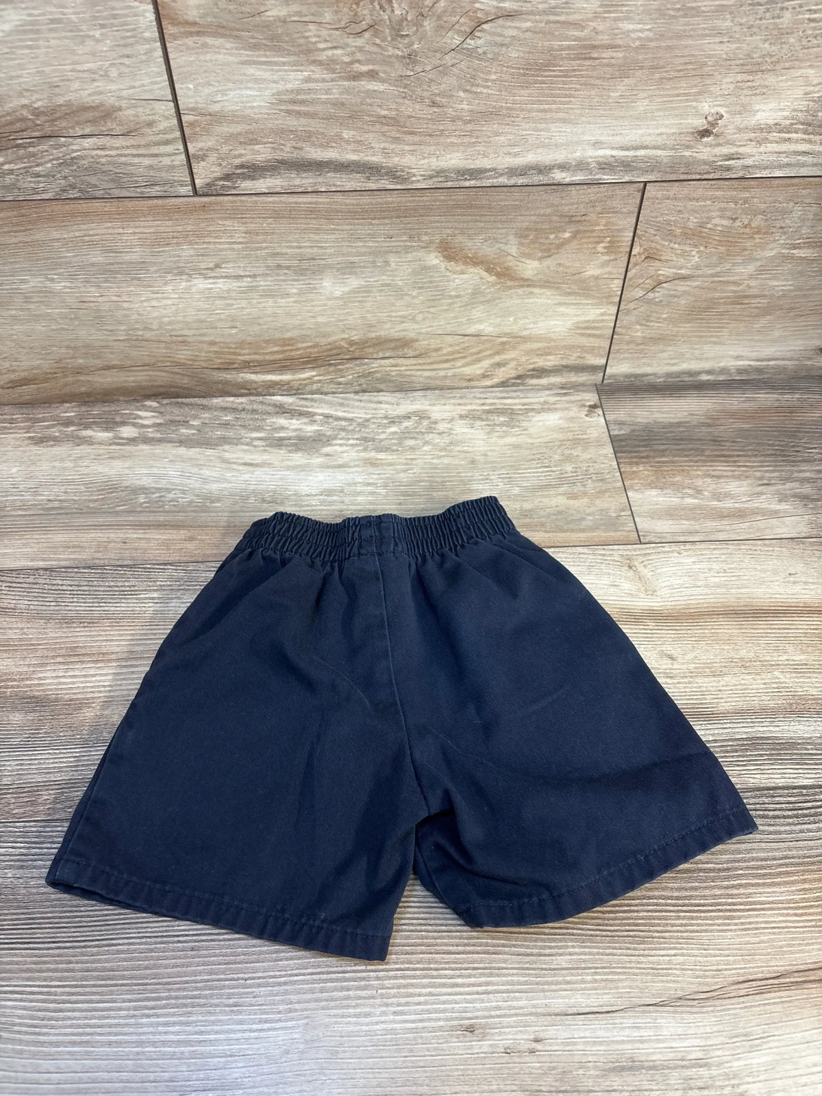 Navy blue kids shorts with elastic waistband on wooden floor