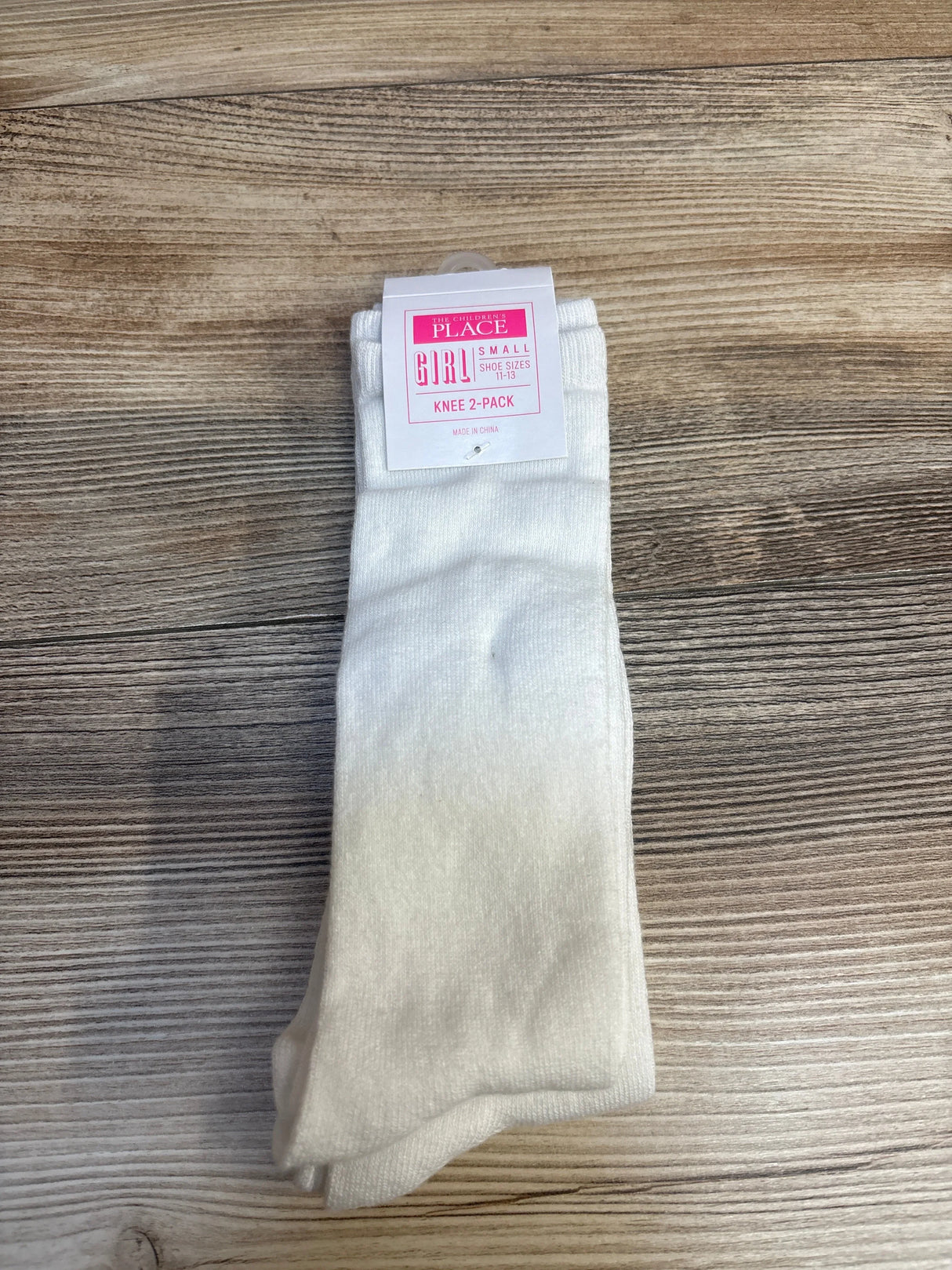White knee socks two-pack for girls, small size, on wood background