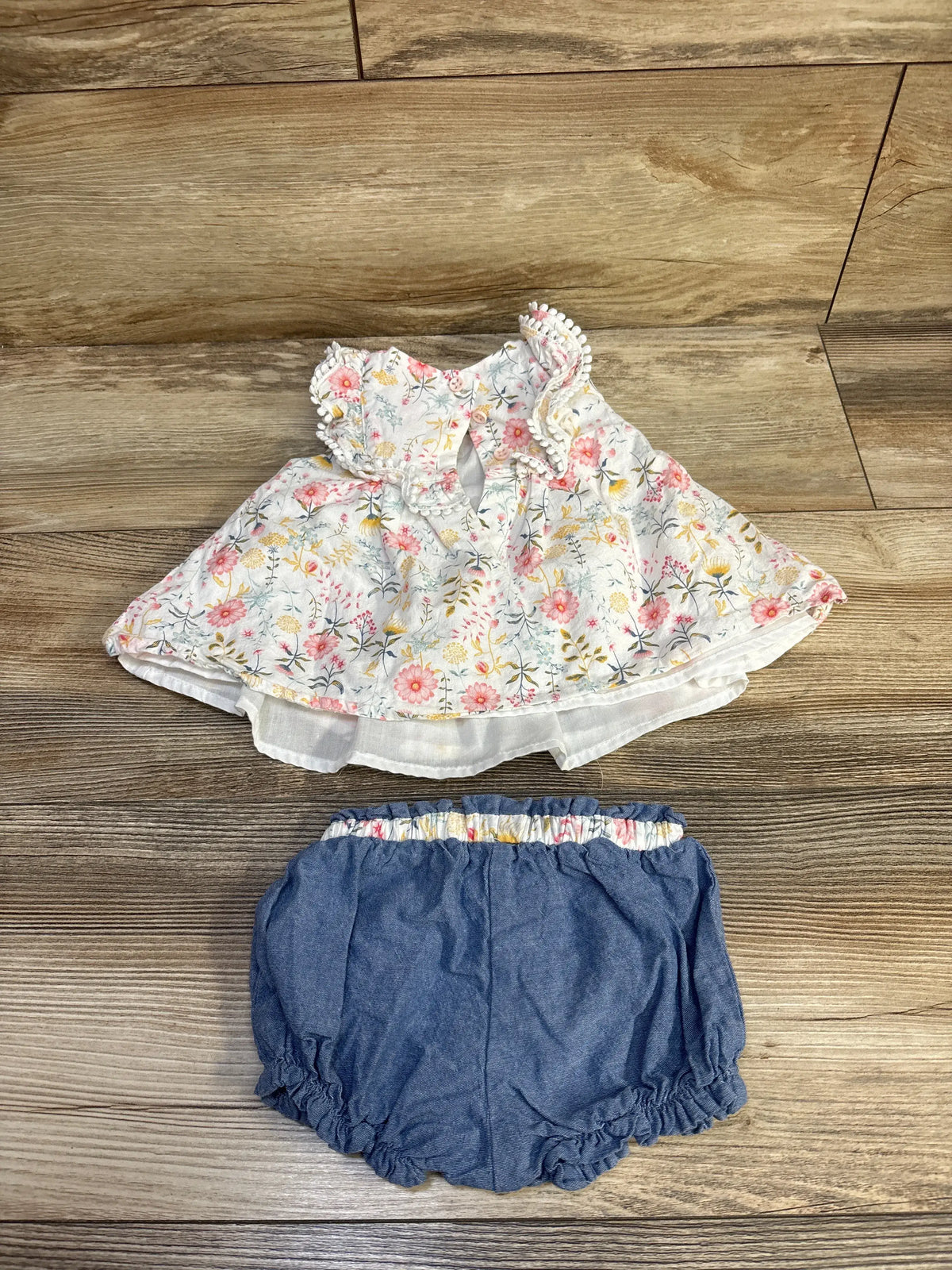 Flat lay of Tommy Bahama infant set showcasing a floral sleeveless top with white lining and chambray shorts
