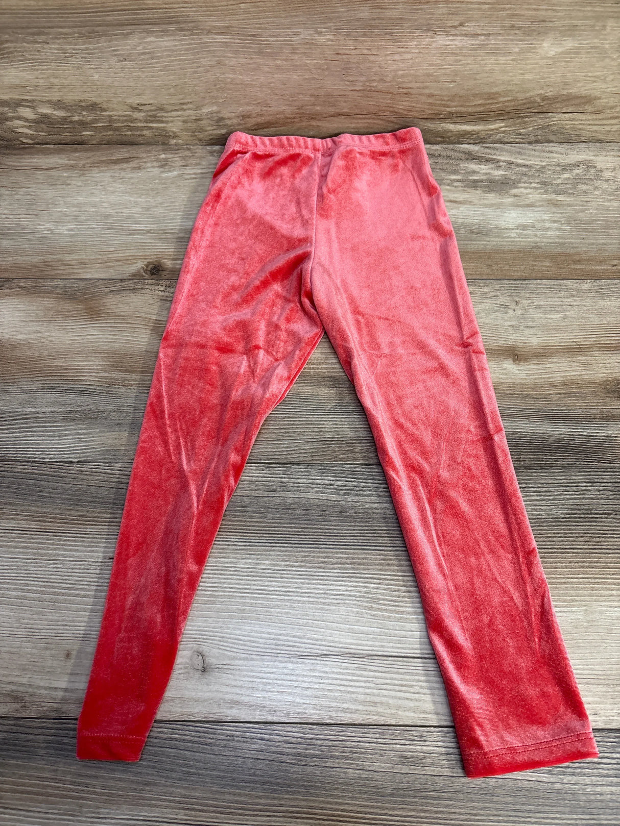 Pink velvet kids leggings on wooden floor, soft texture, elastic waist