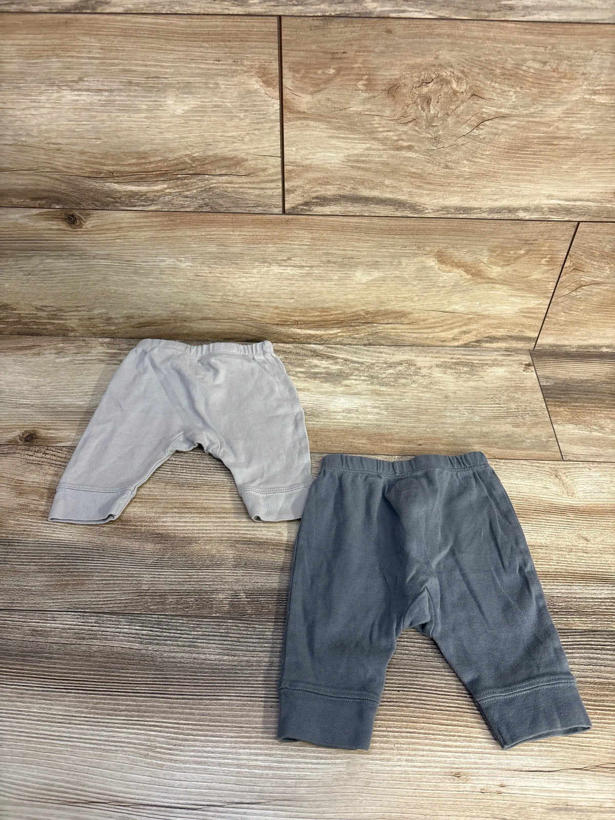 Top view of Cloud Island 2pk pull-on pants showcasing two gray pairs and elastic waistbands on a wood floor