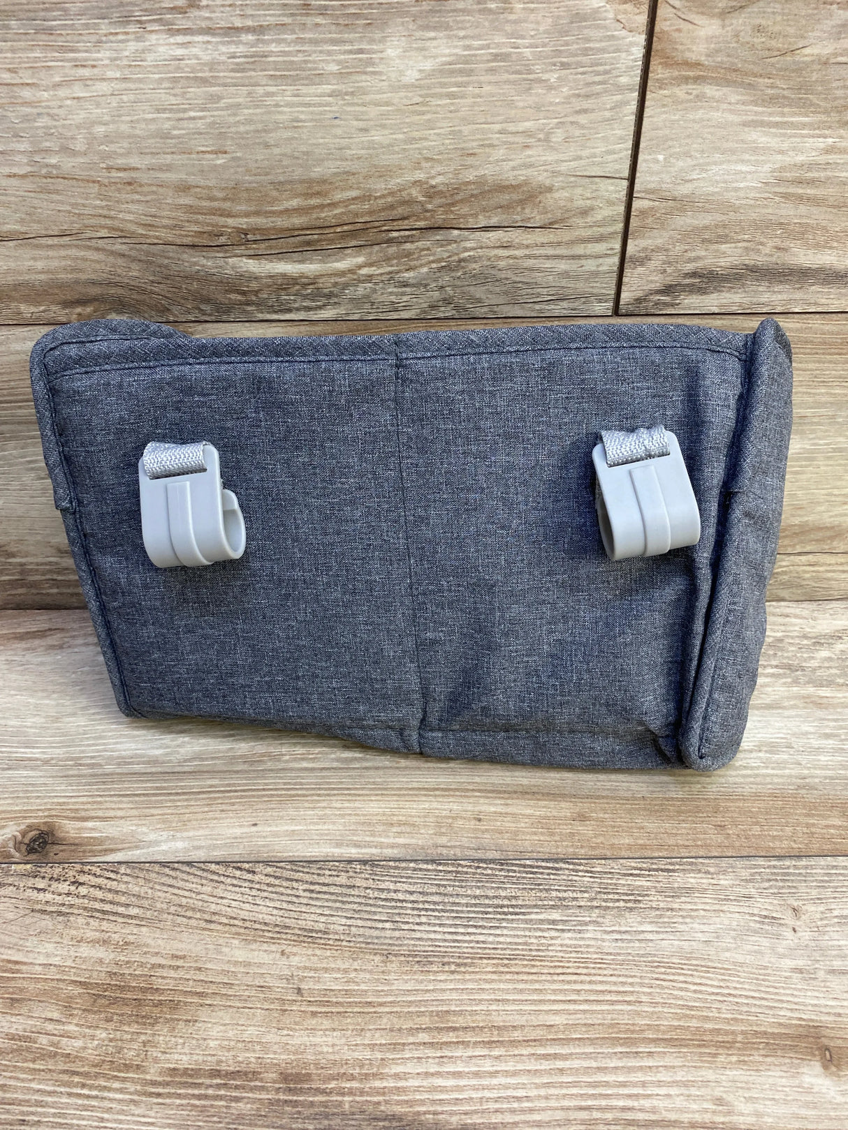 Rear view of grey playard organizer showcasing two plastic hanging hooks and straps on a wood background