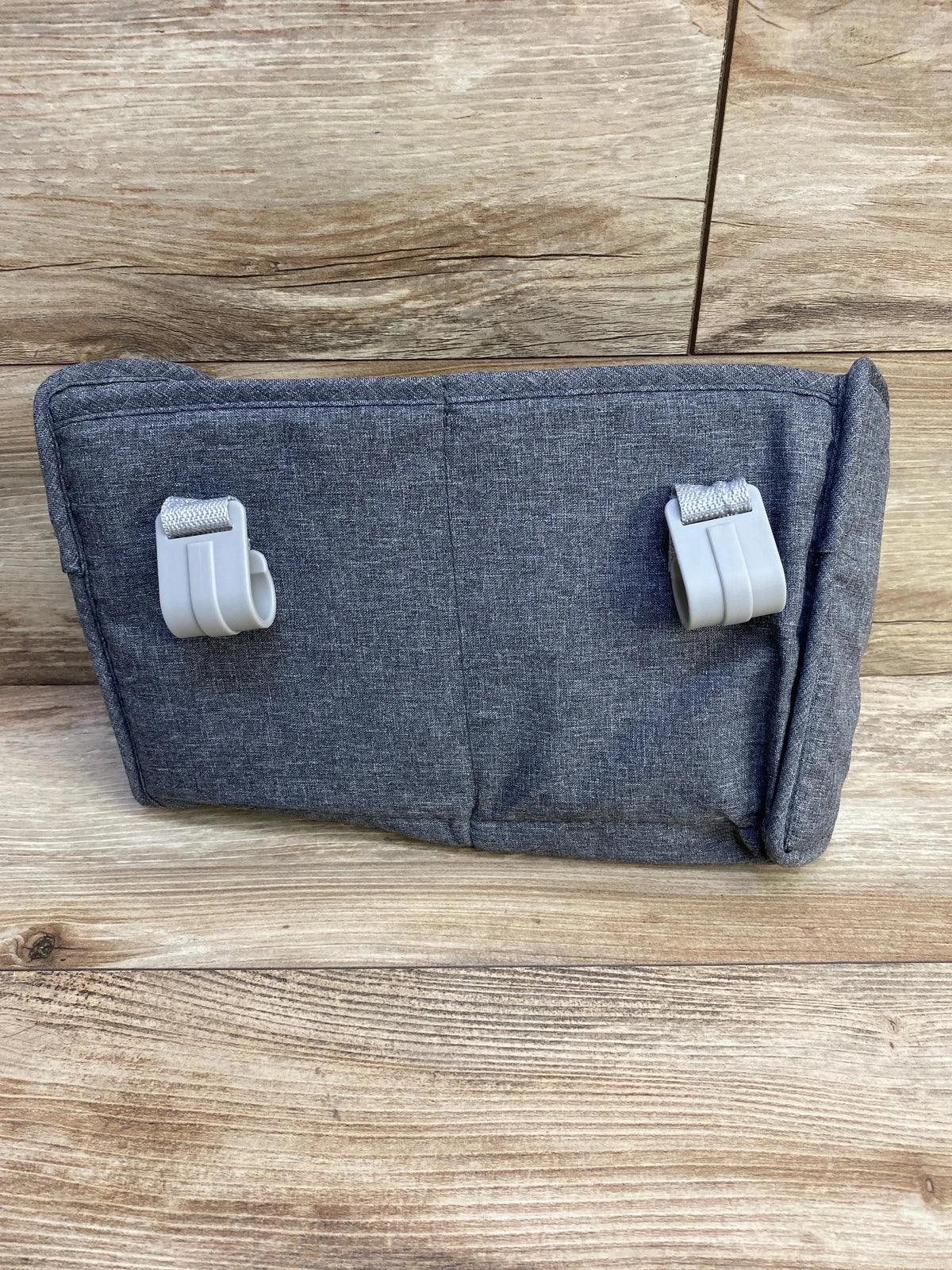 Rear view of grey playard organizer showcasing two plastic hanging hooks and straps on a wood background