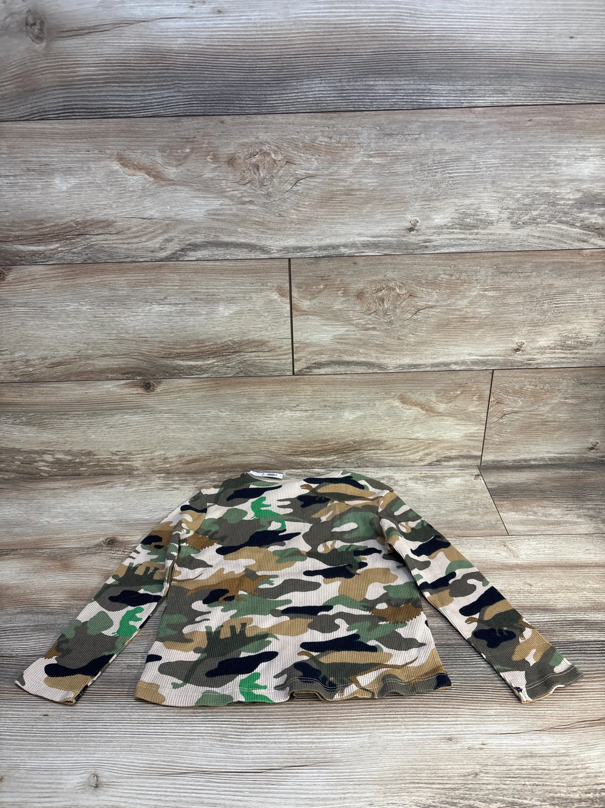 Flat lay of NEW Old Navy Camo Waffle Knit Shirt sz 5T showcasing green brown and cream camouflage print with long sleeves on wood plank background