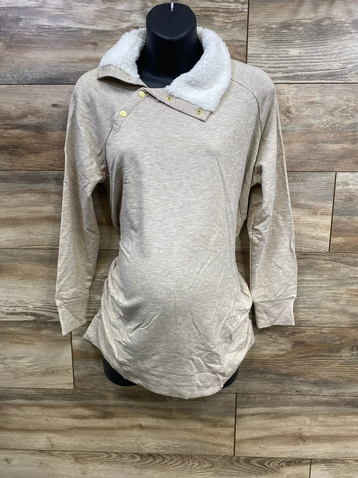 Front view of Isabel maternity oatmeal sweatshirt with sherpa snap collar and ruched belly on mannequin against wood background
