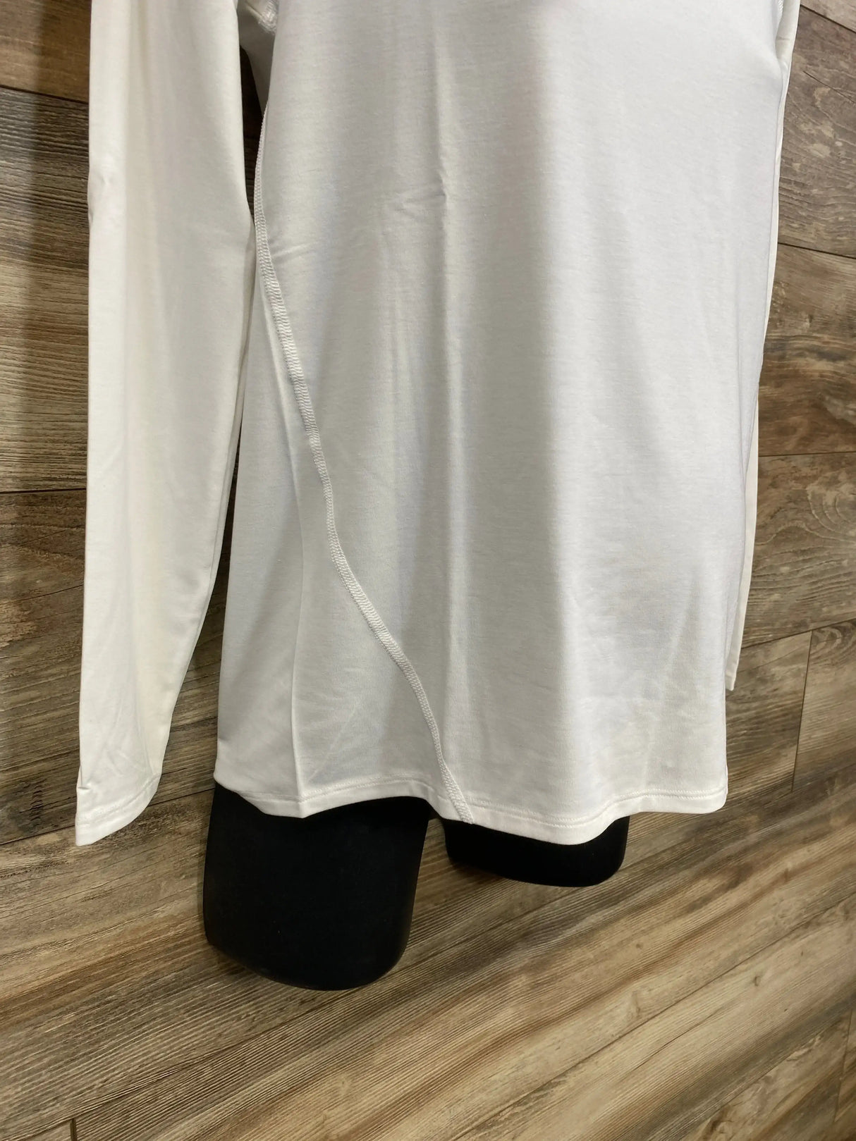 Front view of white Gap maternity long-sleeve Breathe shirt showing side seam and fitted torso on black mannequin