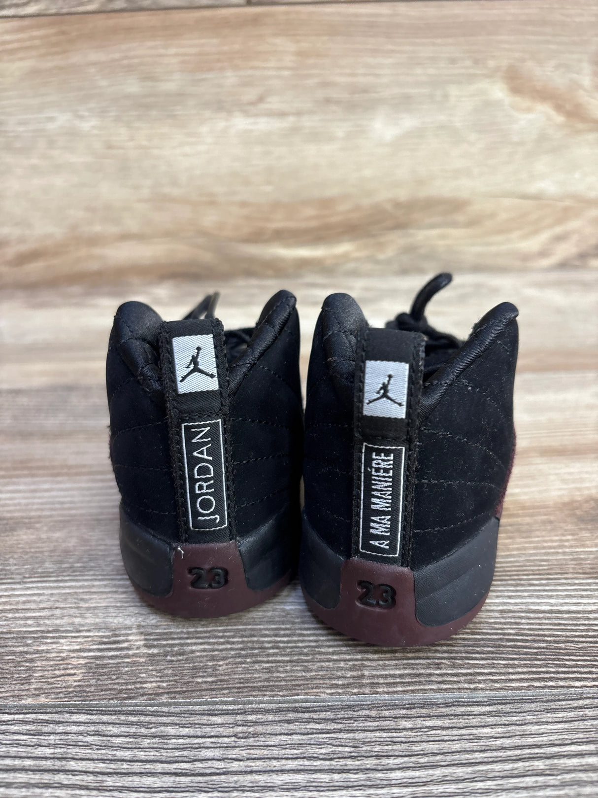 Back view of black Jordan 12 A Ma Maniere sneakers with Jumpman logo and 23 heel details