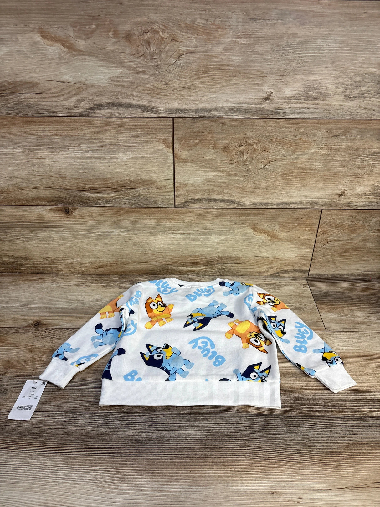 Kids Bluey cartoon long sleeve shirt with yellow and blue character print on wood floor