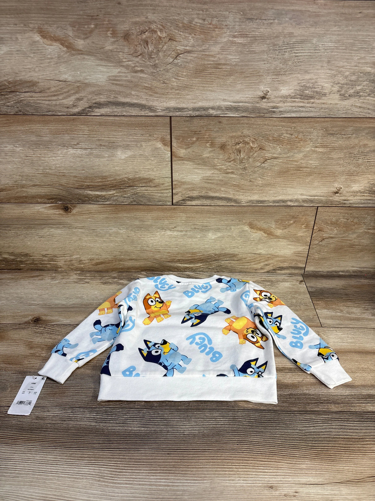 Kids Bluey cartoon long sleeve shirt with yellow and blue character print on wood floor