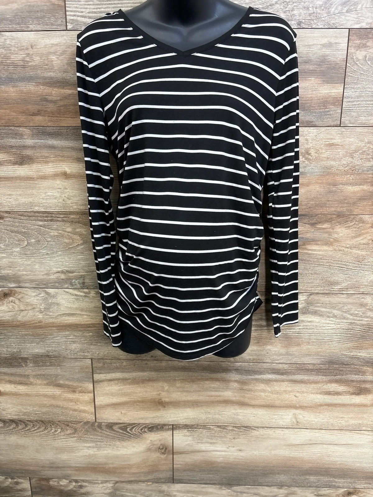 Front view of black Time & Tru striped long sleeve maternity shirt showcasing side ruching with a wood-look floor background