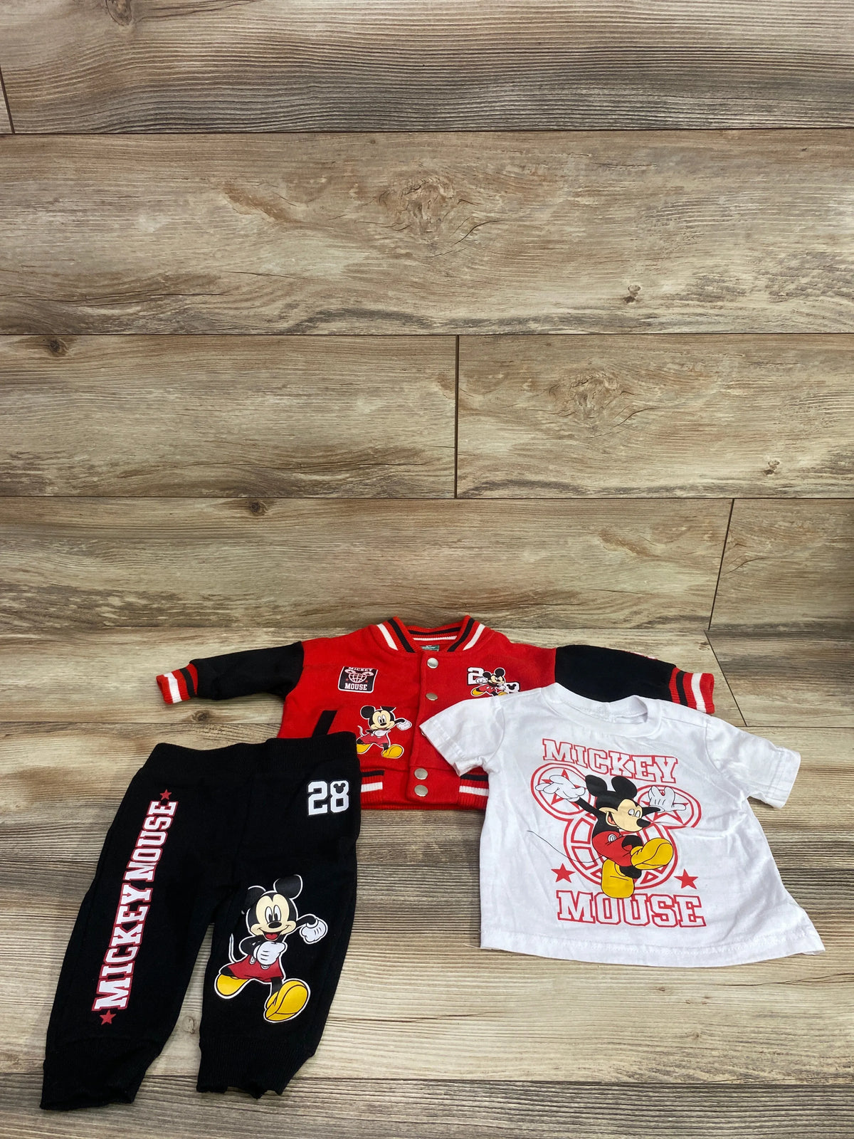 Disney Baby 3-piece set including a red varsity jacket, white t-shirt, and black joggers.