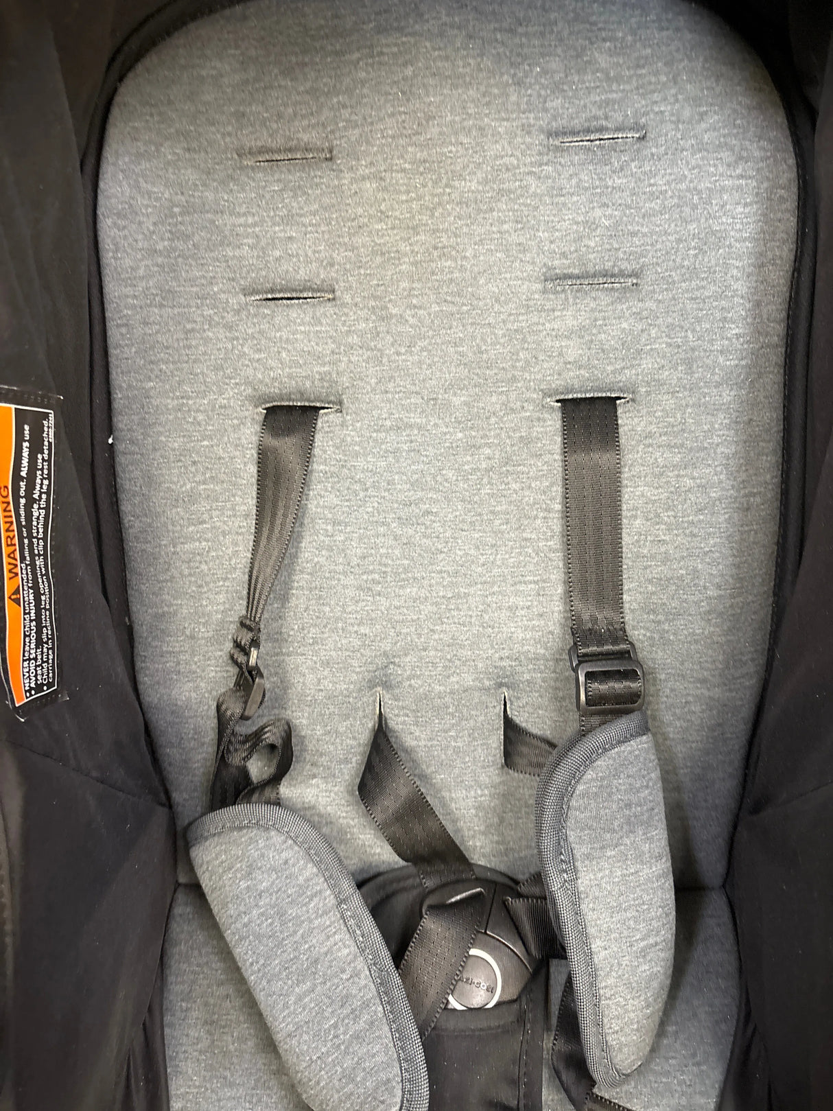 Gray padded baby stroller seat with adjustable safety straps and harness