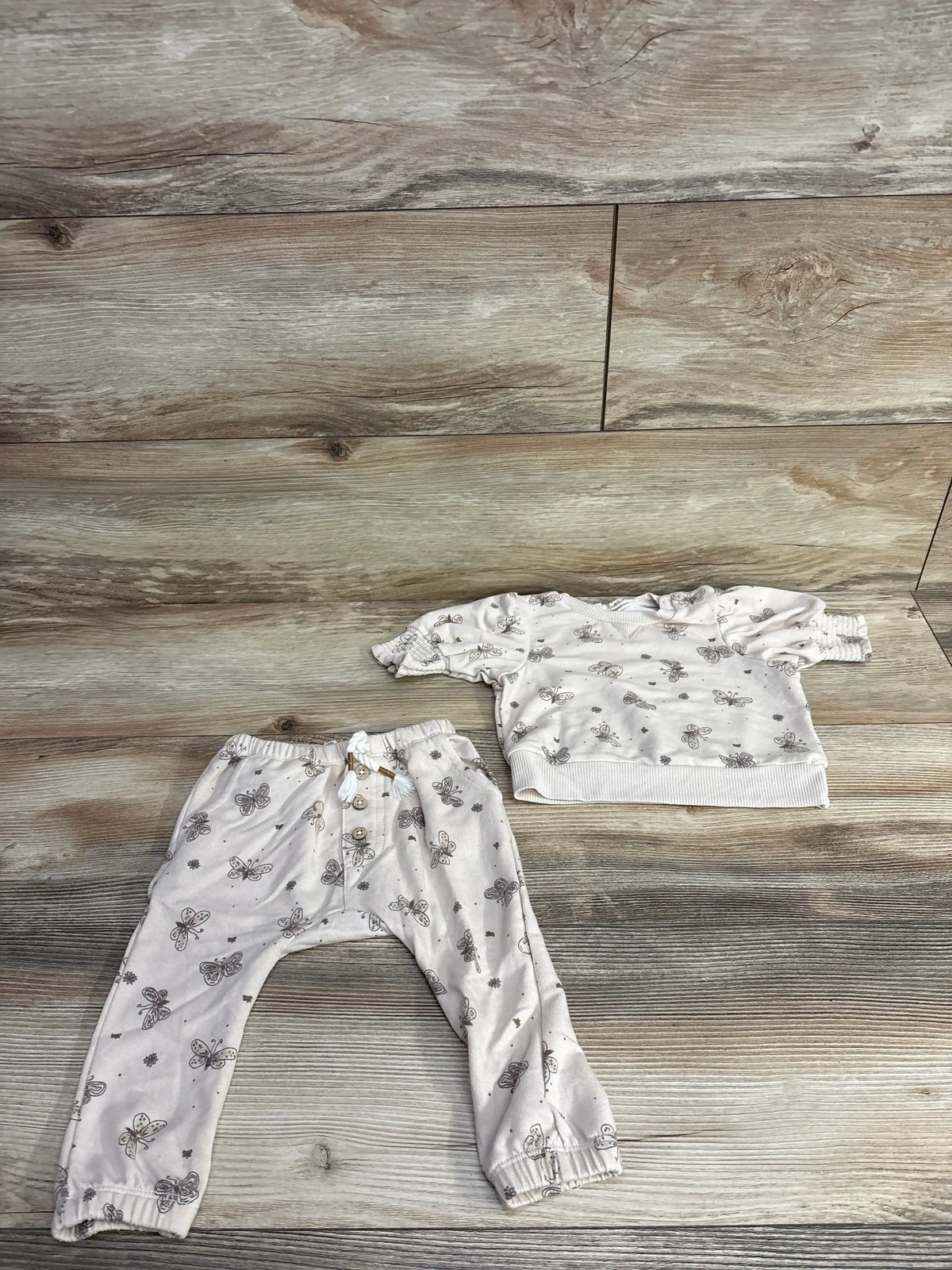 Children's two-piece outfit with butterfly print, comprising long-sleeve top and elastic waist pants on wooden floor