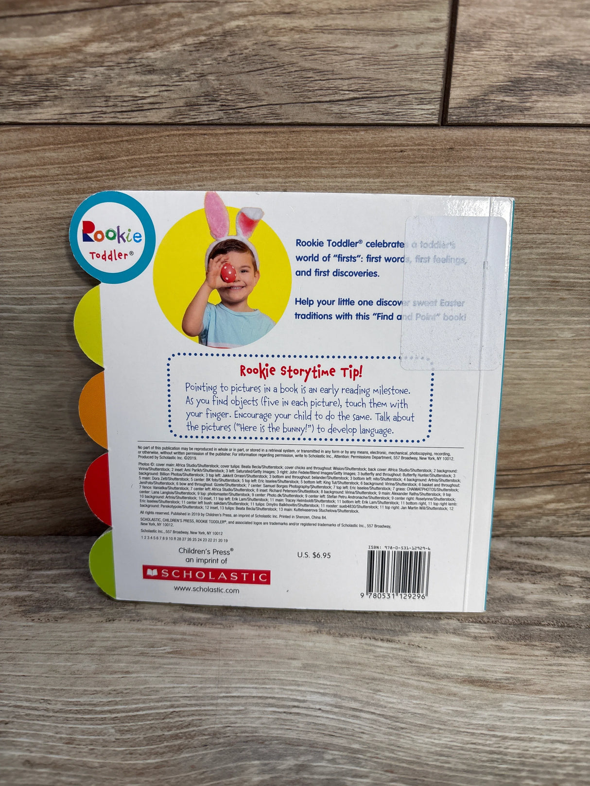 Back cover of Rookie Toddler book with colorful tabs, child in bunny ears holding Easter egg, reading tip, and Scholastic logo