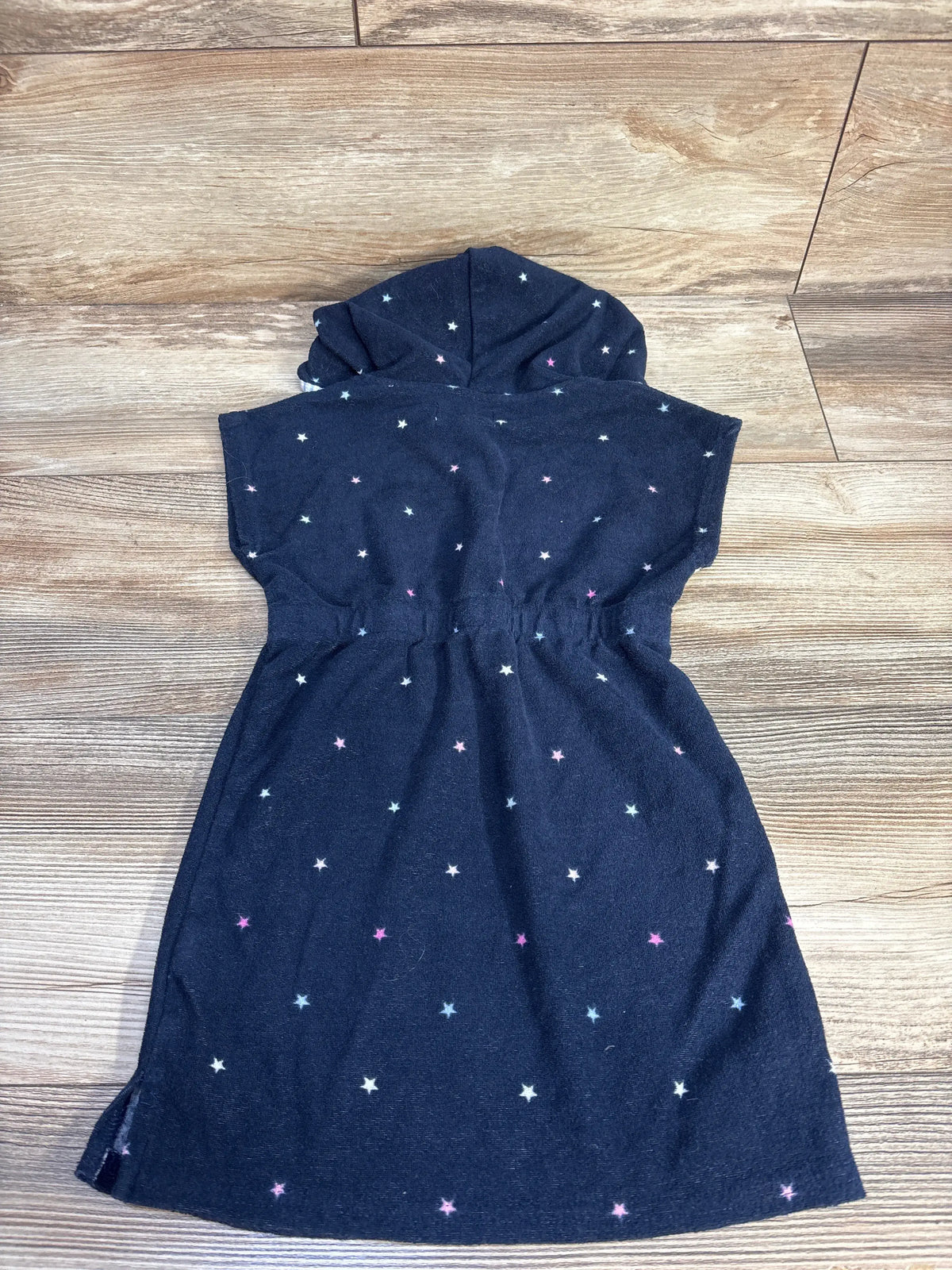Back view of Crown + Ivy Kids navy hooded terry cloth swim cover up with colorful stars and elasticized waist on wood-look floor