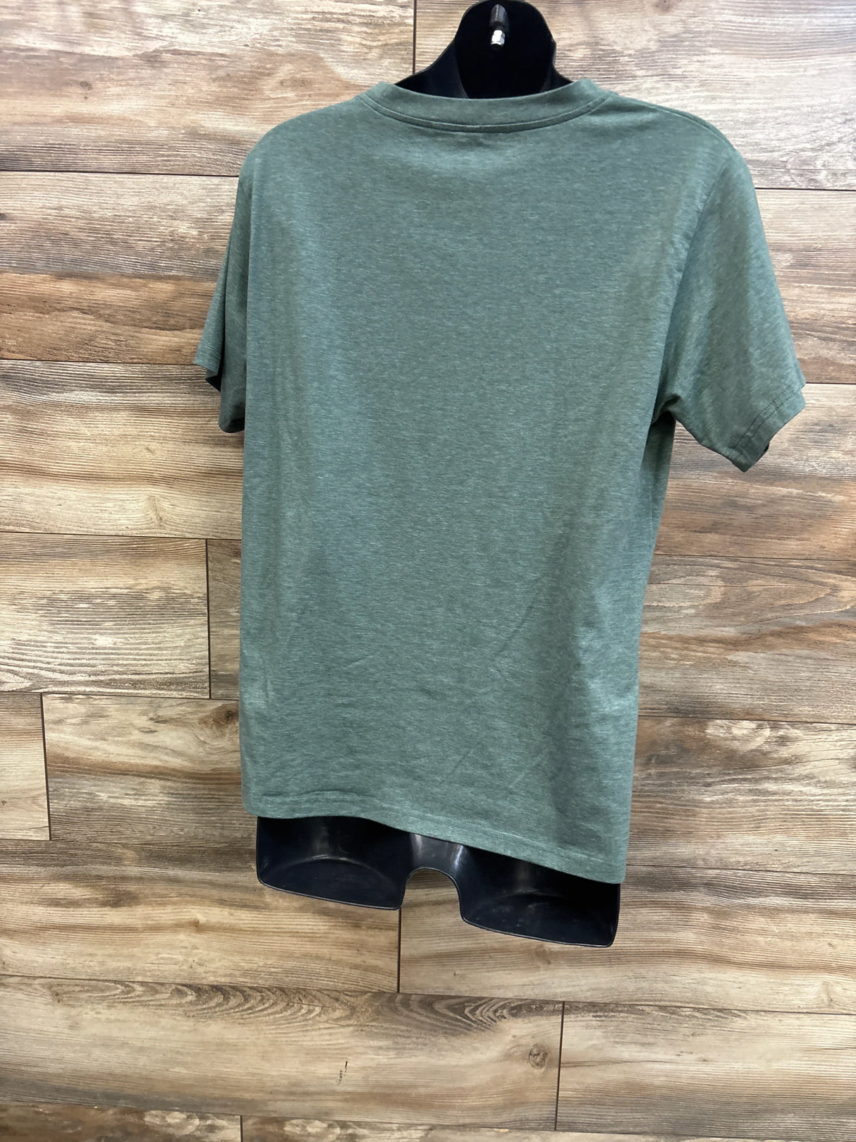 Back view of zippered nursing t-shirt in green showing short sleeves and crew neck on black mannequin with wood background