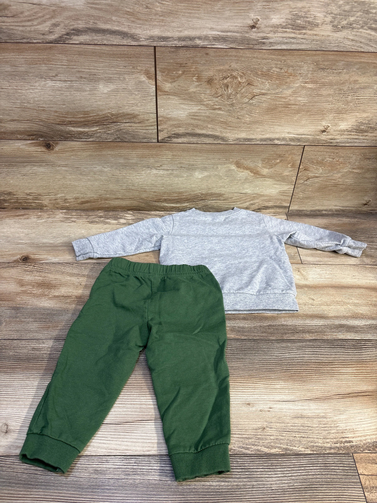 Flat lay of Carters two piece pullover sweatshirt and joggers set in size 12 months, with gray sweatshirt and dark green cuffed pants