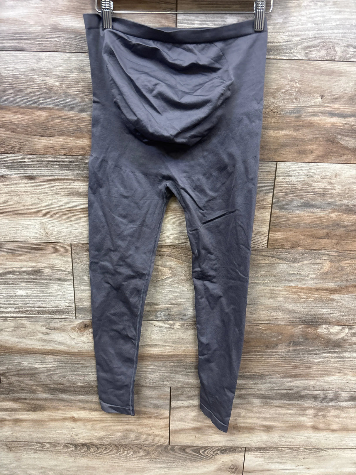 Gray maternity leggings with over-belly panel displayed on wooden floor