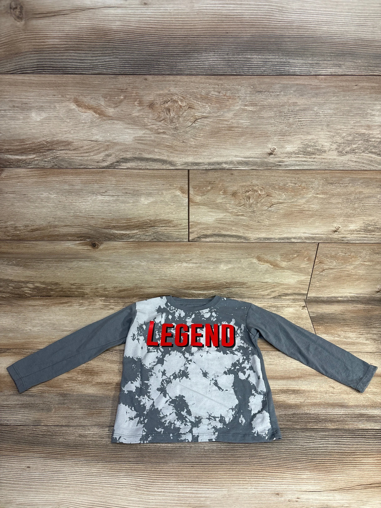 Kids gray tie-dye long sleeve shirt with red LEGEND graphic on wood background