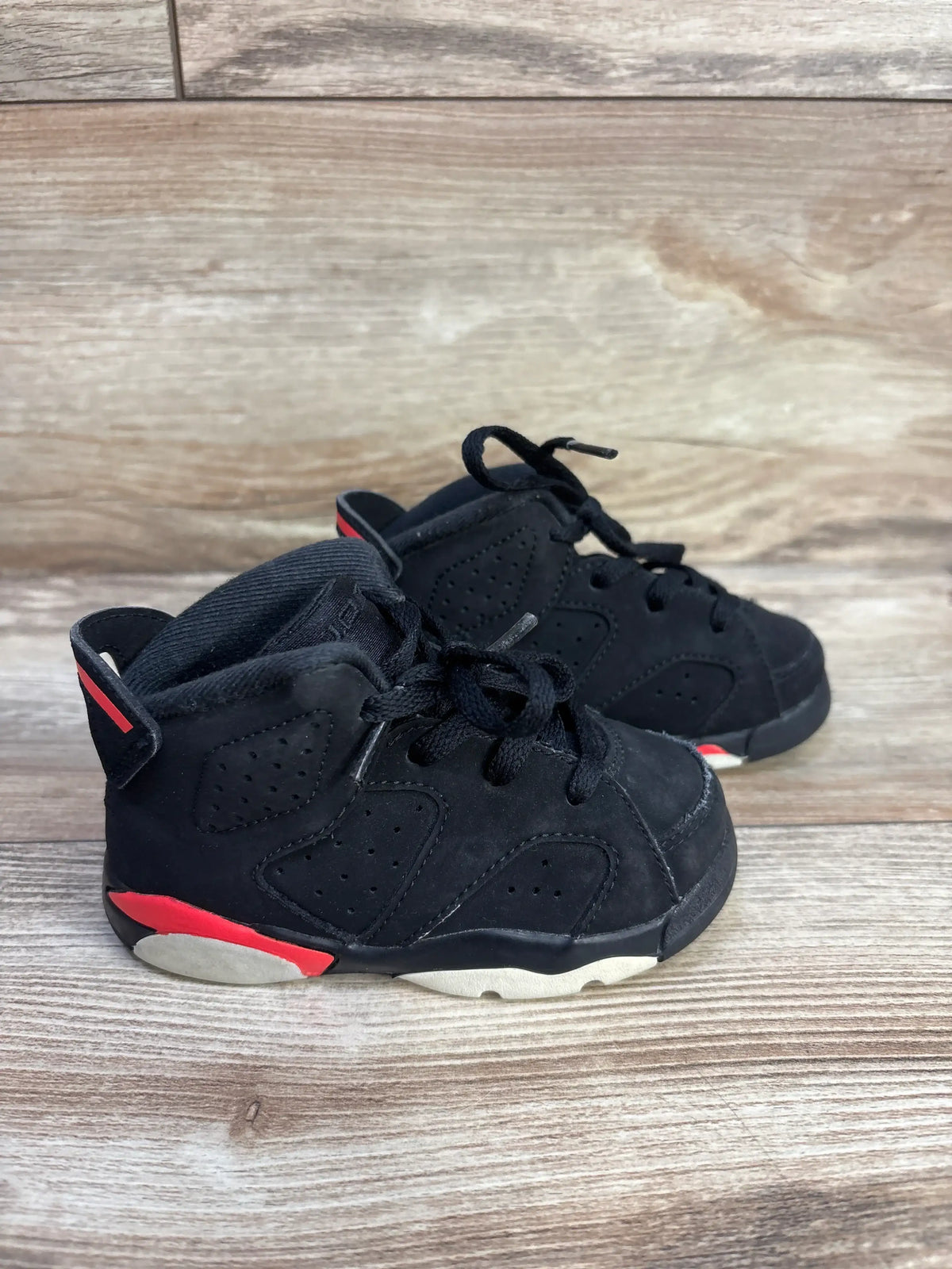 Three-quarter view of Air Jordan 6 Retro TD Infrared sneakers with perforated black suede, red accents, and two-tone outsole