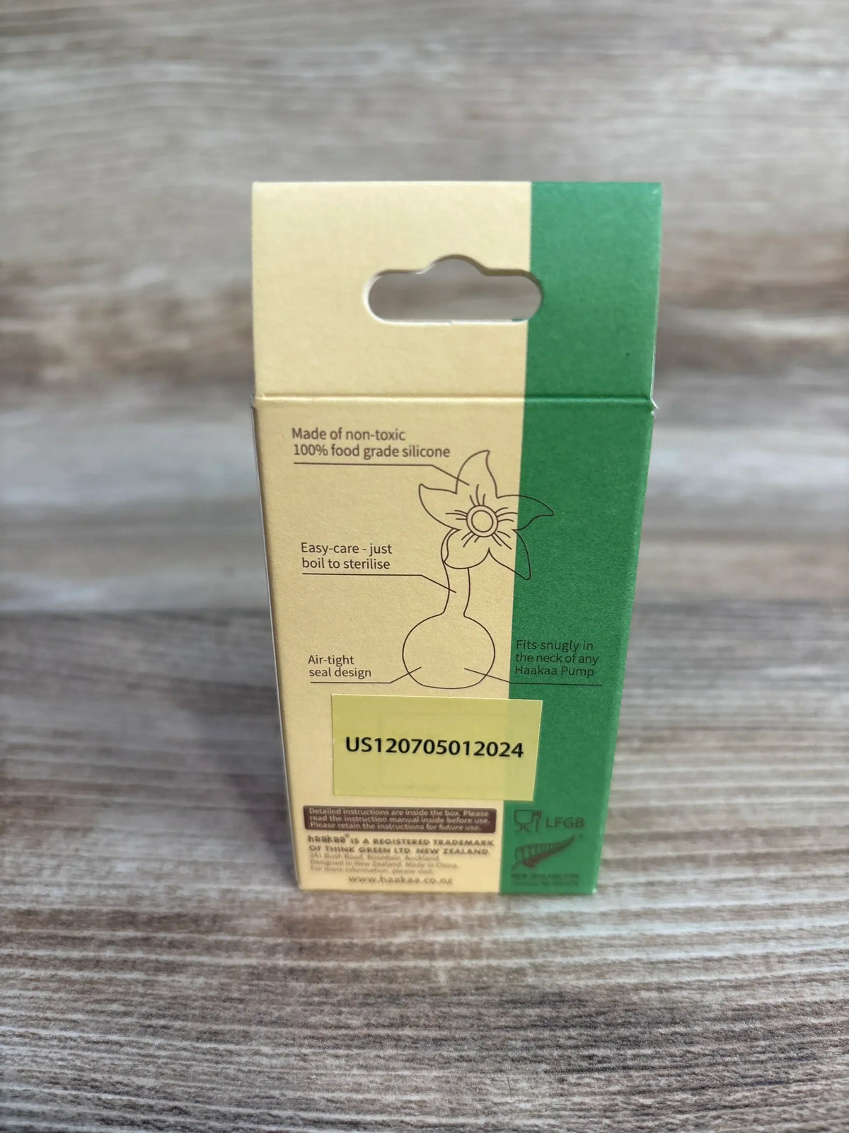 Back of NEW haakaa silicone flower stopper packaging showcasing product features and diagram on wood plank flooring
