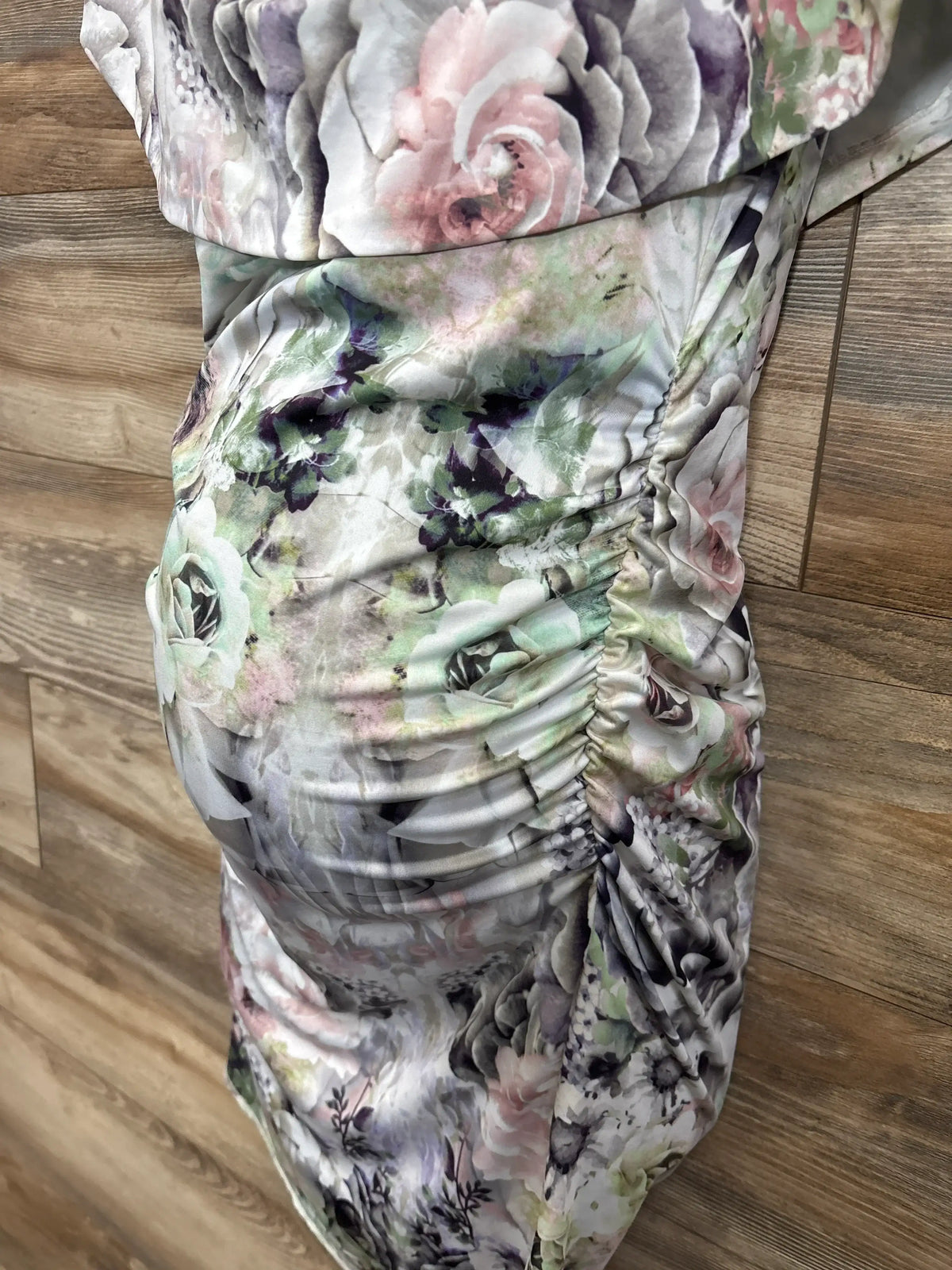 Floral maternity dress with ruched sides on wood background