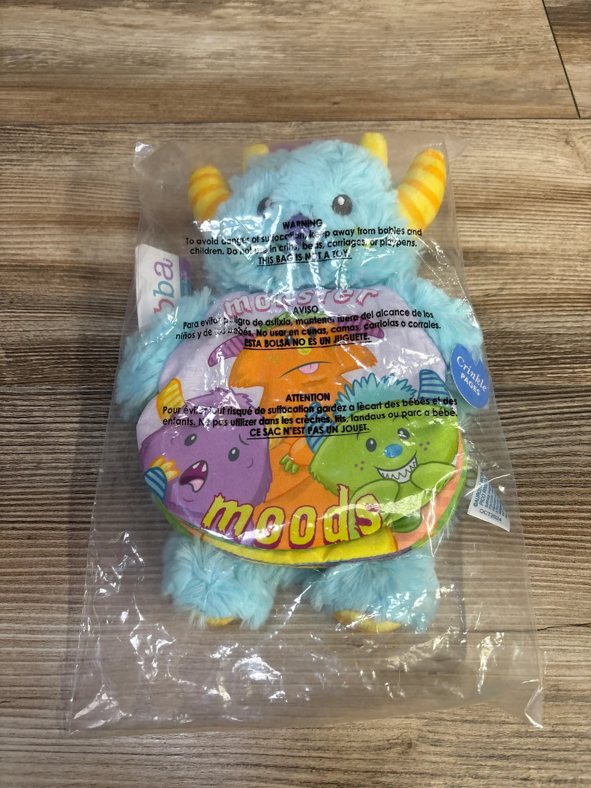 Front view of ebba Baby Talk Story Pals Monster Moods plush book with blue monster and crinkly storybook in clear packaging