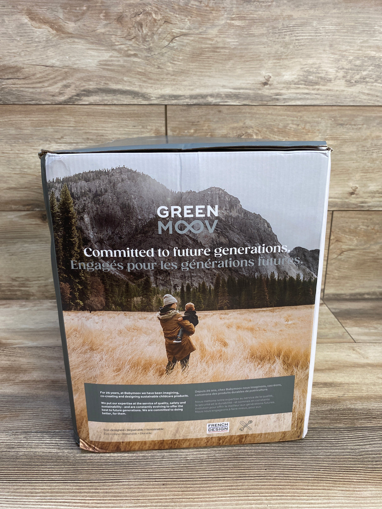 Green Moov packaging with mountain landscape, adult holding child in field, eco-friendly message