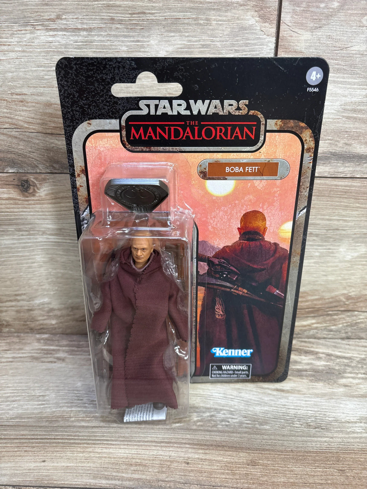 Front view of Boba Fett action figure in brown cloth robe, Kenner blister packaging with desert-sunset card background