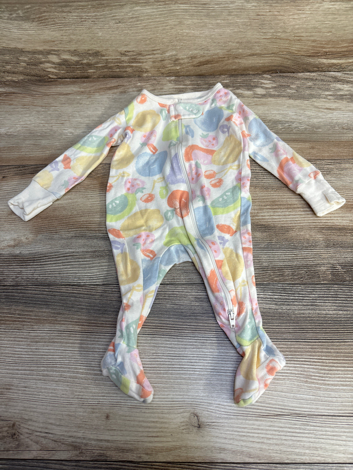 Pastel fruit print baby sleeper with zipper on wood background