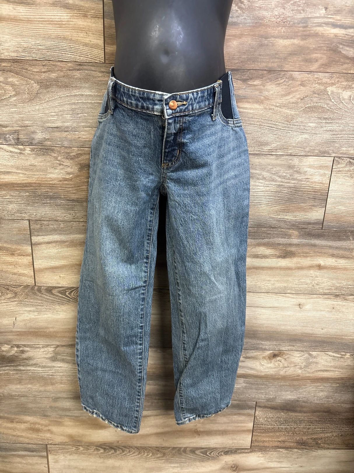 Front view of Isabel maternity straight blue jeans on black mannequin with side elastic panels, raw hem, straight legs on wood background