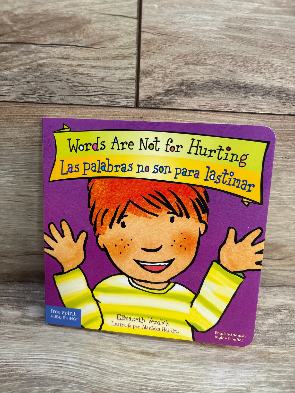 Bilingual children's book 'Words Are Not for Hurting' with illustrated smiling child cover