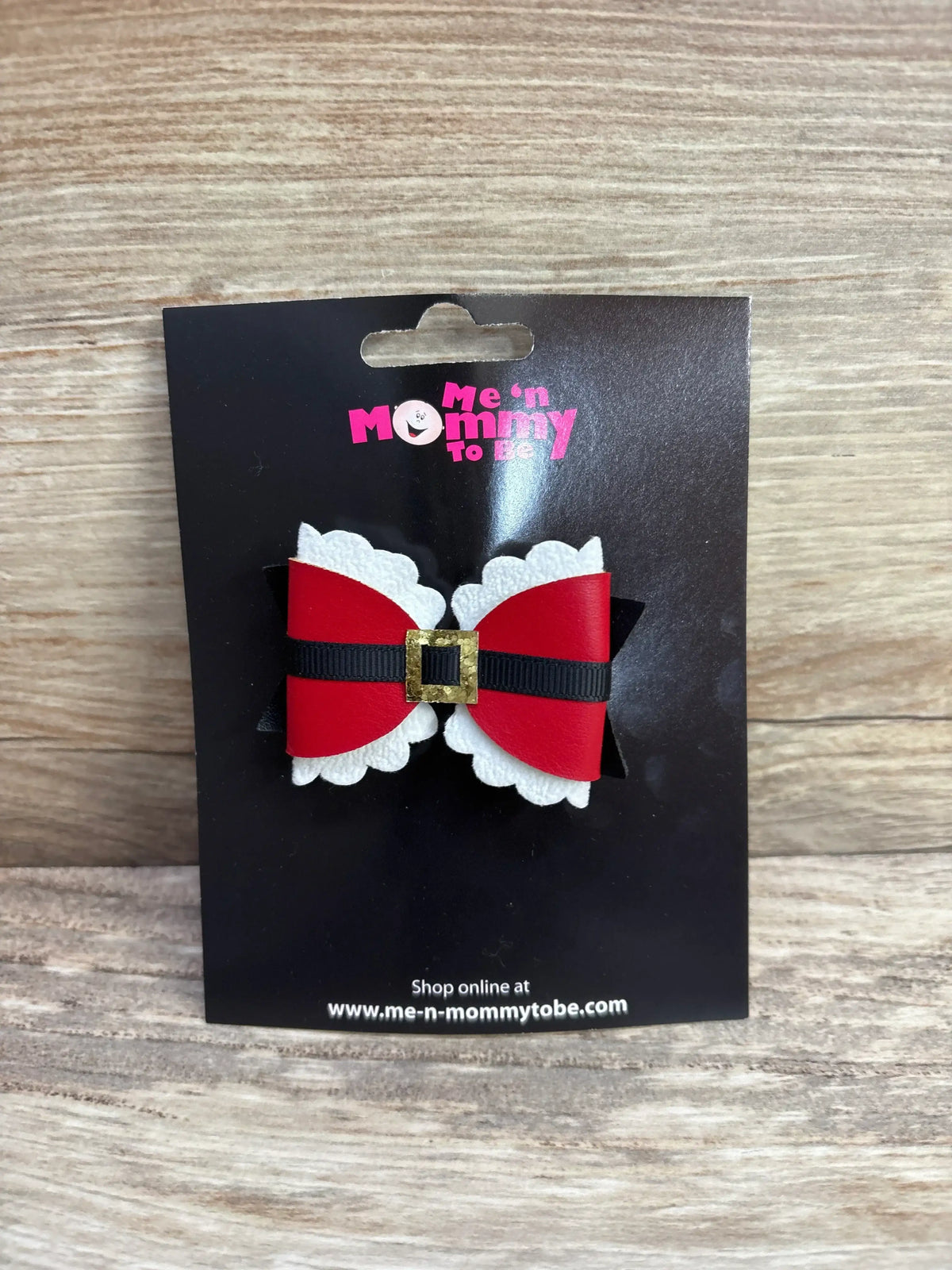 Red and white Santa belt hair bow for baby or toddler, festive holiday accessory on black card