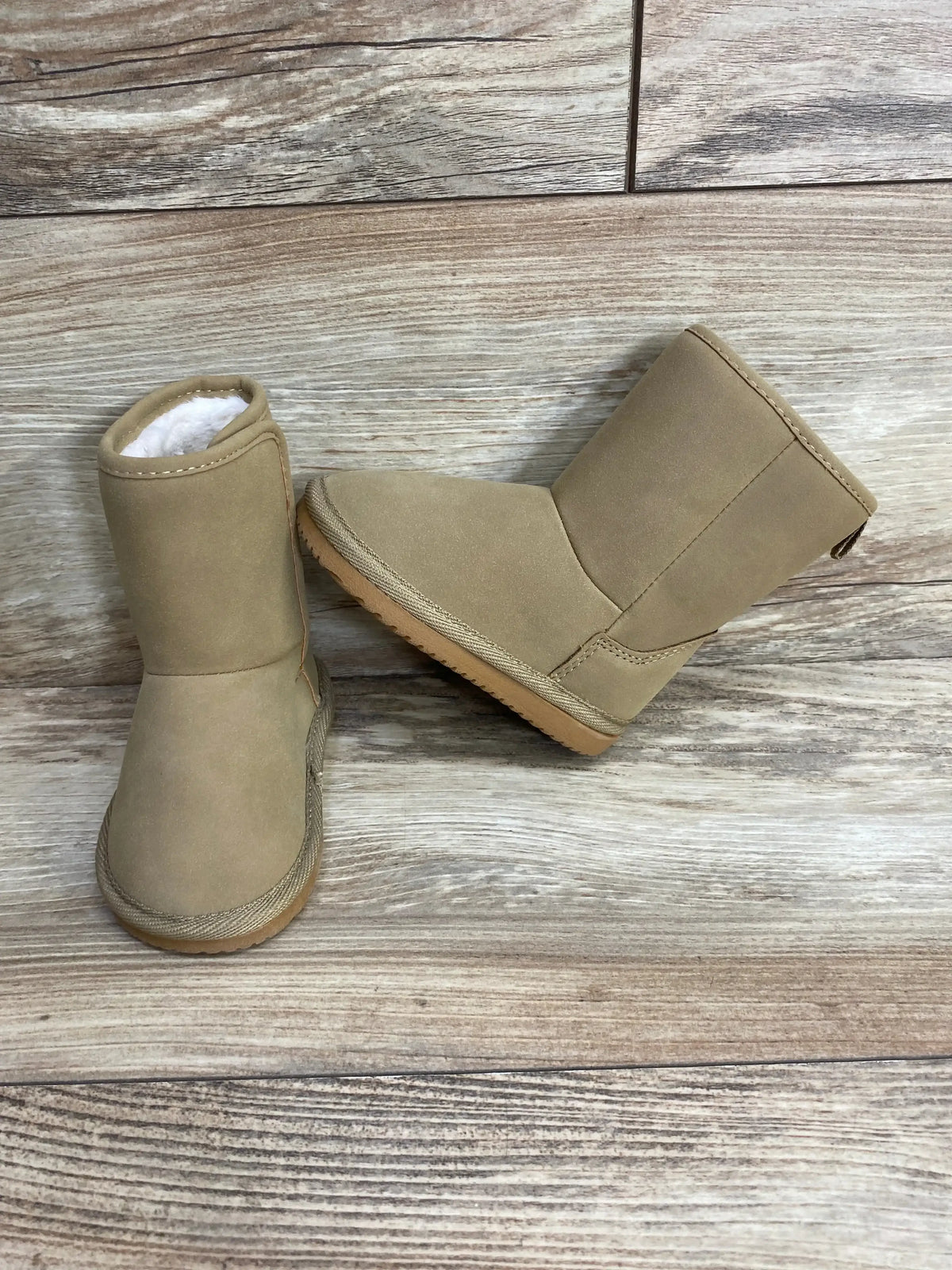 Beige toddler winter boots with faux fur lining on wood floor