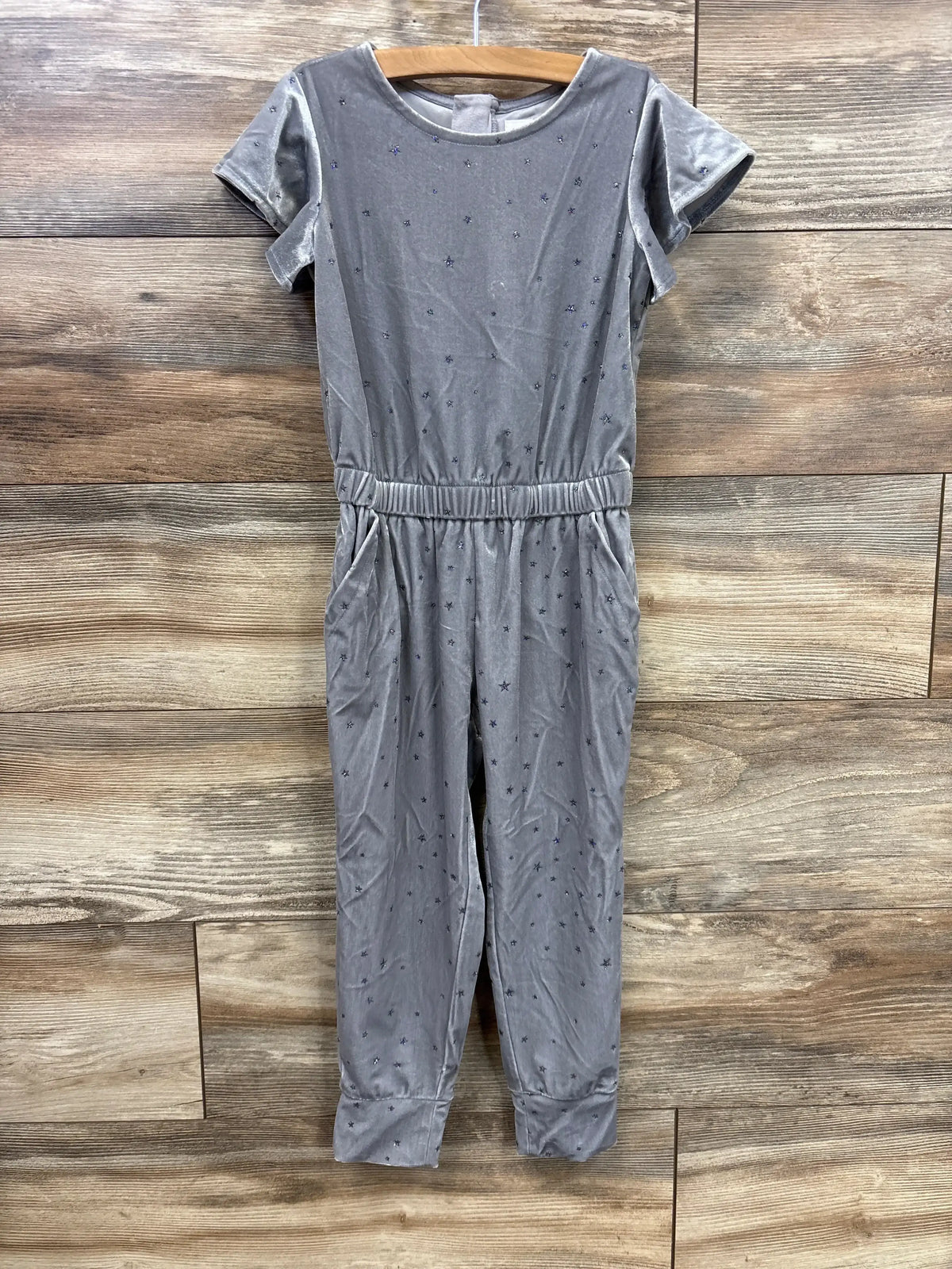 Gray short sleeve star print jumpsuit for girls on wooden background