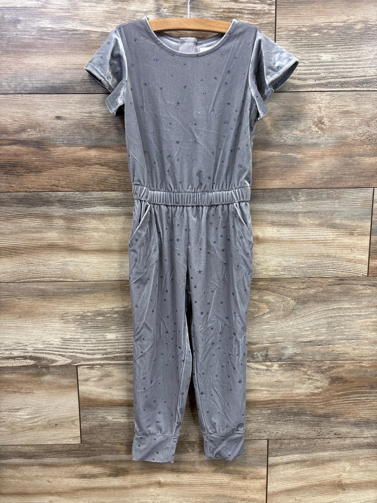 Gray short sleeve star print jumpsuit for girls on wooden background