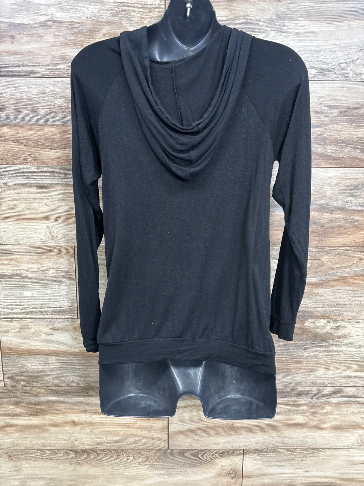 Black long sleeve hoodie on mannequin with wood background, casual pullover style