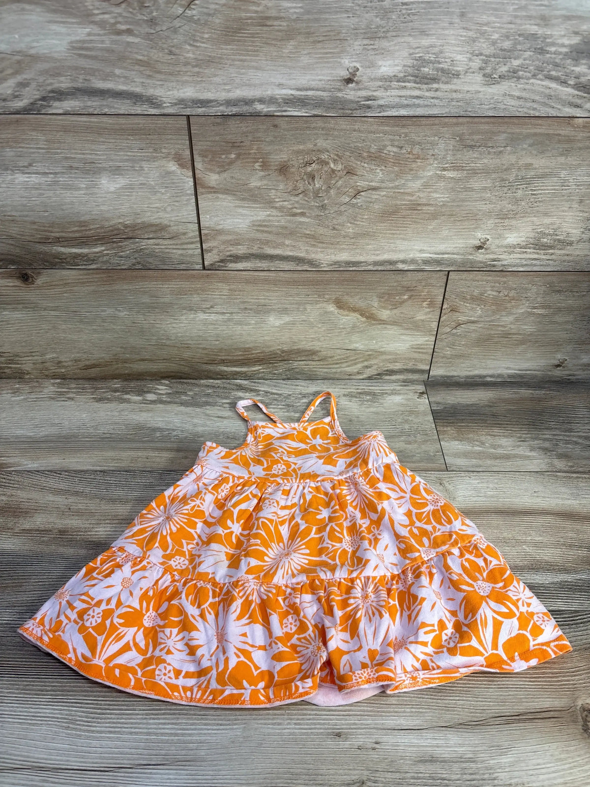 Flat-lay of Cat and Jack orange floral tank dress size 2T showing tiered skirt and thin shoulder straps on wood floor background